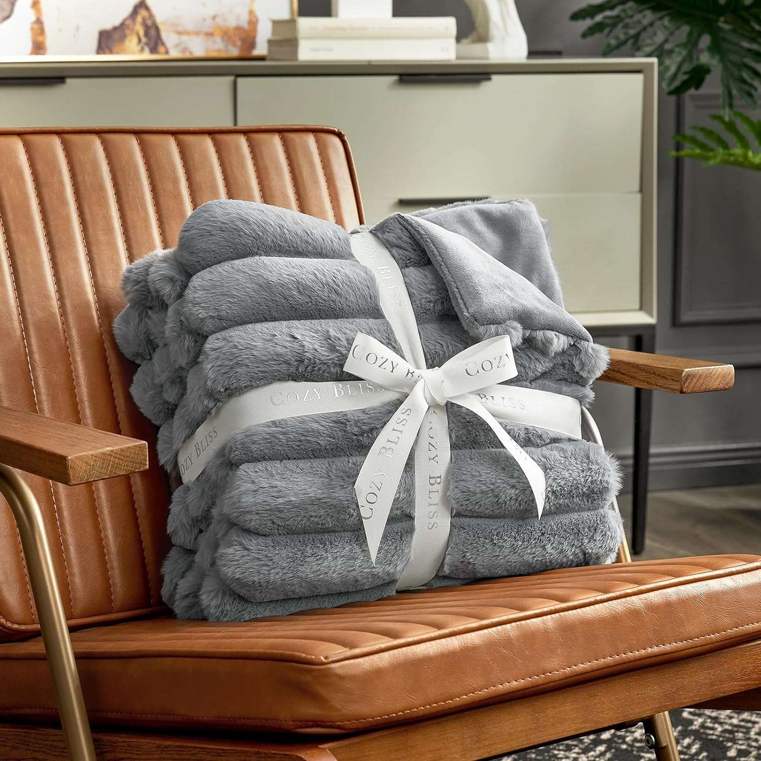 Cozy Bliss grey faux fur blanket, gift-ready and soft. Cozy bedding throw on a brown chair. #color_Grey