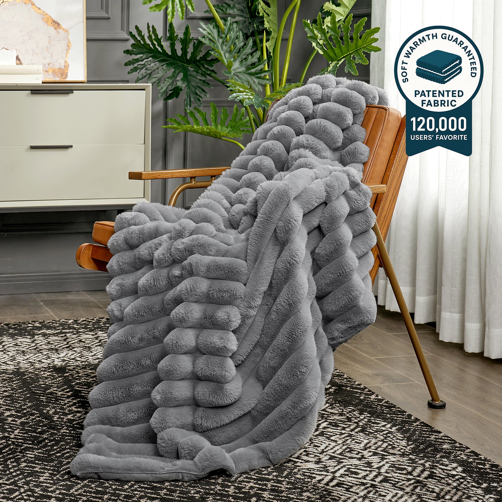 Gray textured blanket draped over a wooden chair in a room with plants and furniture. #color_Grey