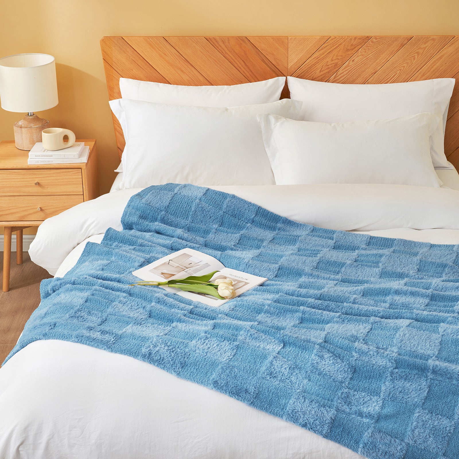Checkered Faux Fur Feather Yarn Throw Blanket in Blue styled on a bed, adding a cozy look. #color_Misty Blue
