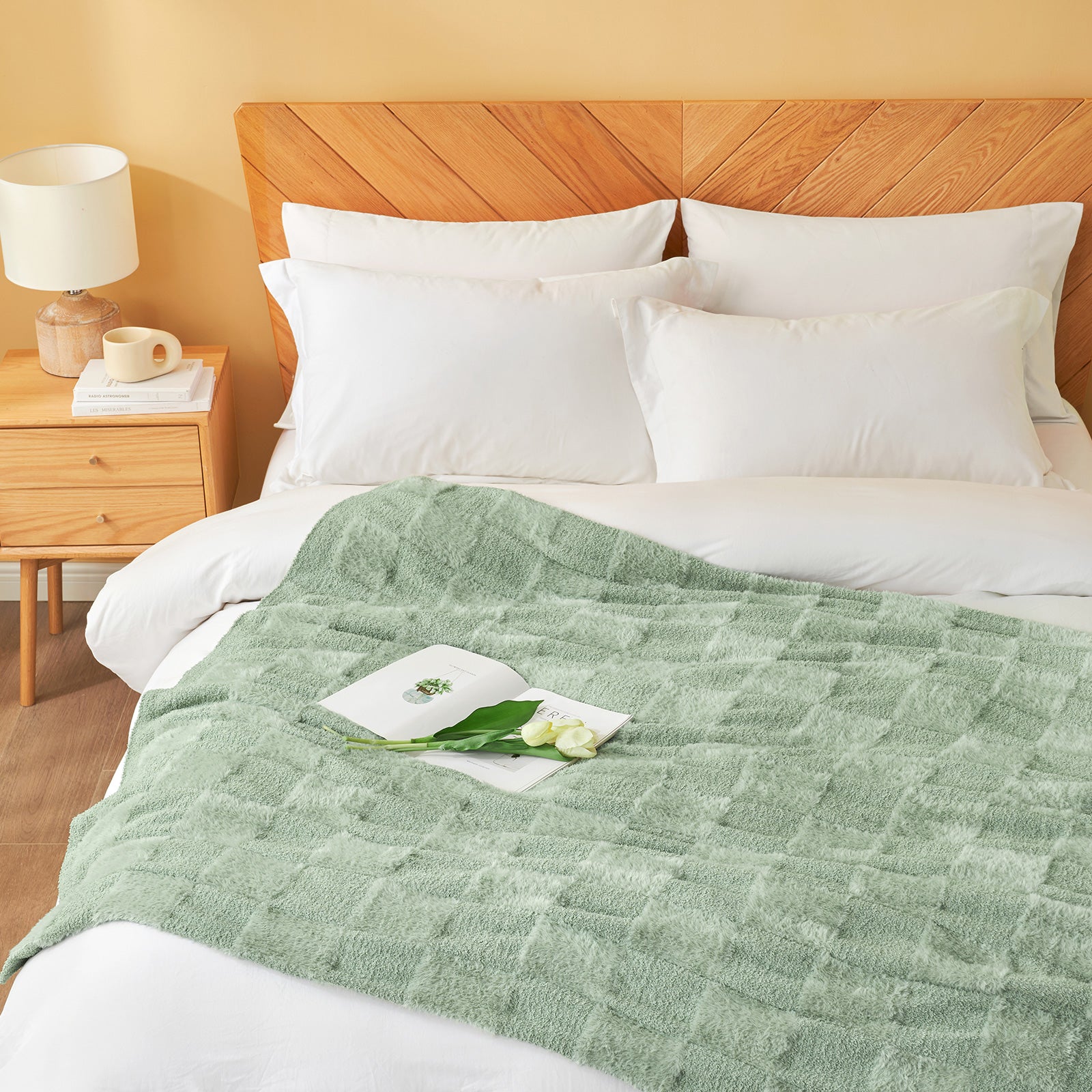 Checkered Faux Fur Feather Yarn Throw Blanket in Sage Green styled on a bed, creating a relaxing atmosphere. #color_Sage Green