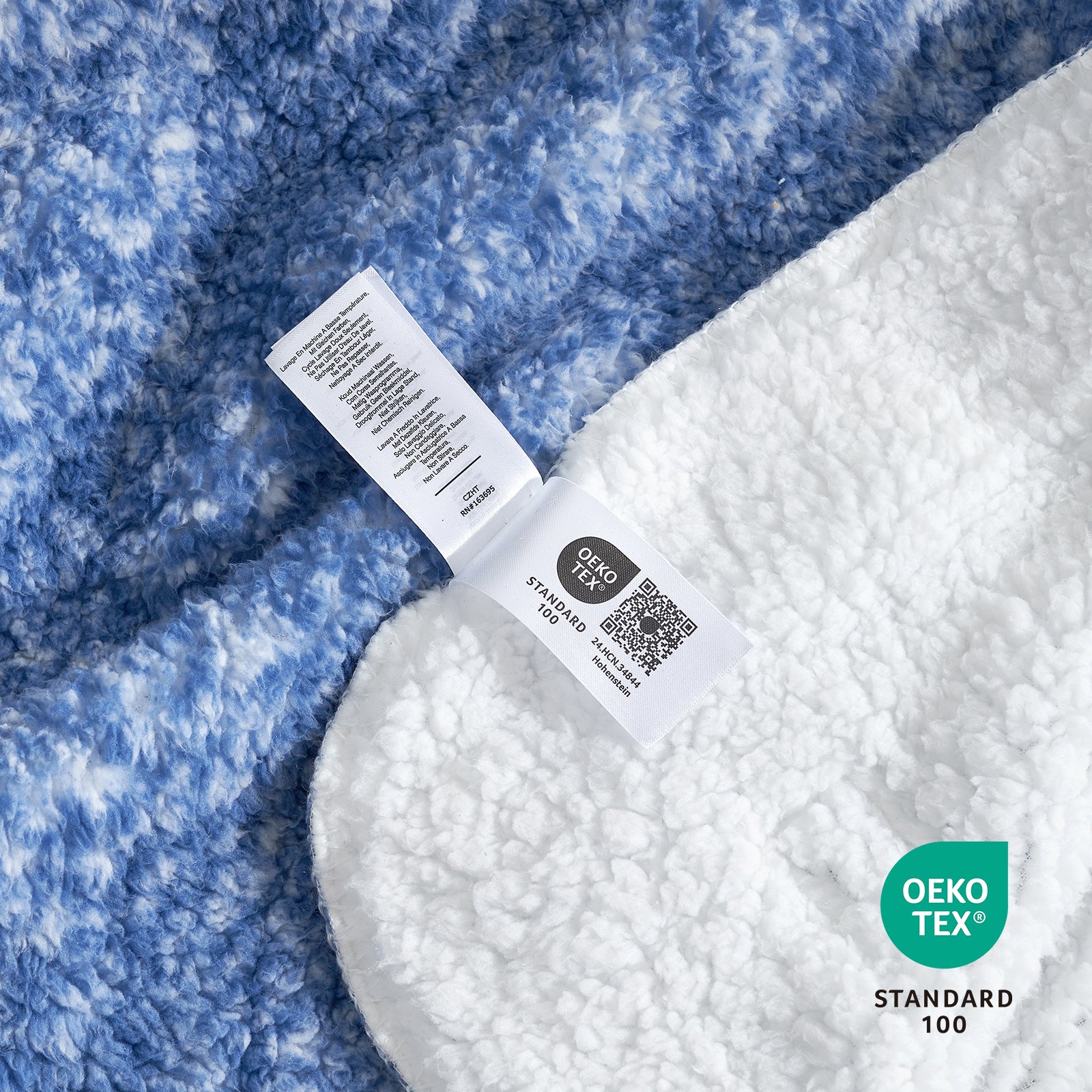 Blue and white reversible Cozy Bliss Sherpa blanket detail with OEKO-TEX label. Soft, cozy bedding. #color_ Mottled Navy Blue