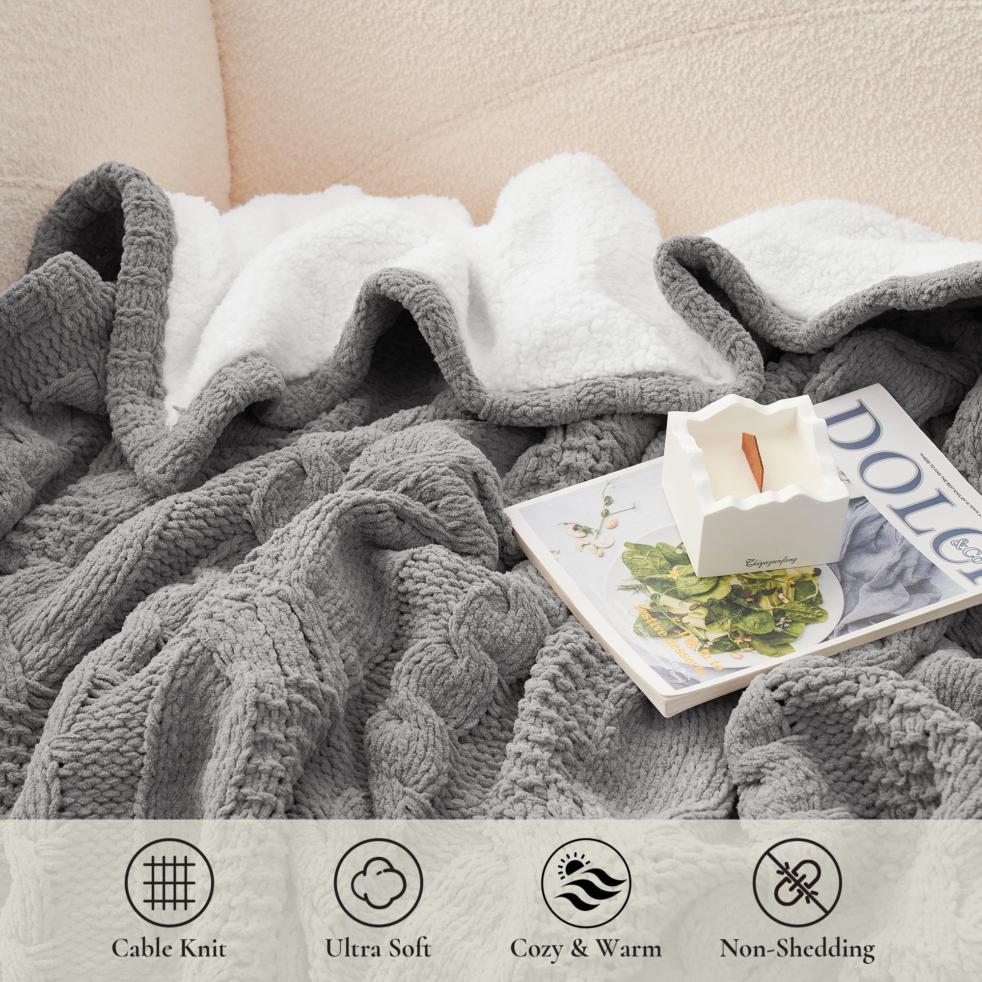 Gray cable knit blanket draped over a surface with a magazine underneath, featuring product features at the bottom. #Color_Grey