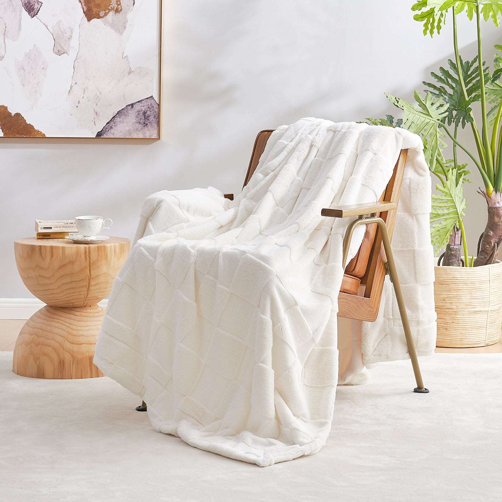 Cream-colored faux fur throw blanket draped over a wooden chair, cozy bedding for home. #color_Ivory