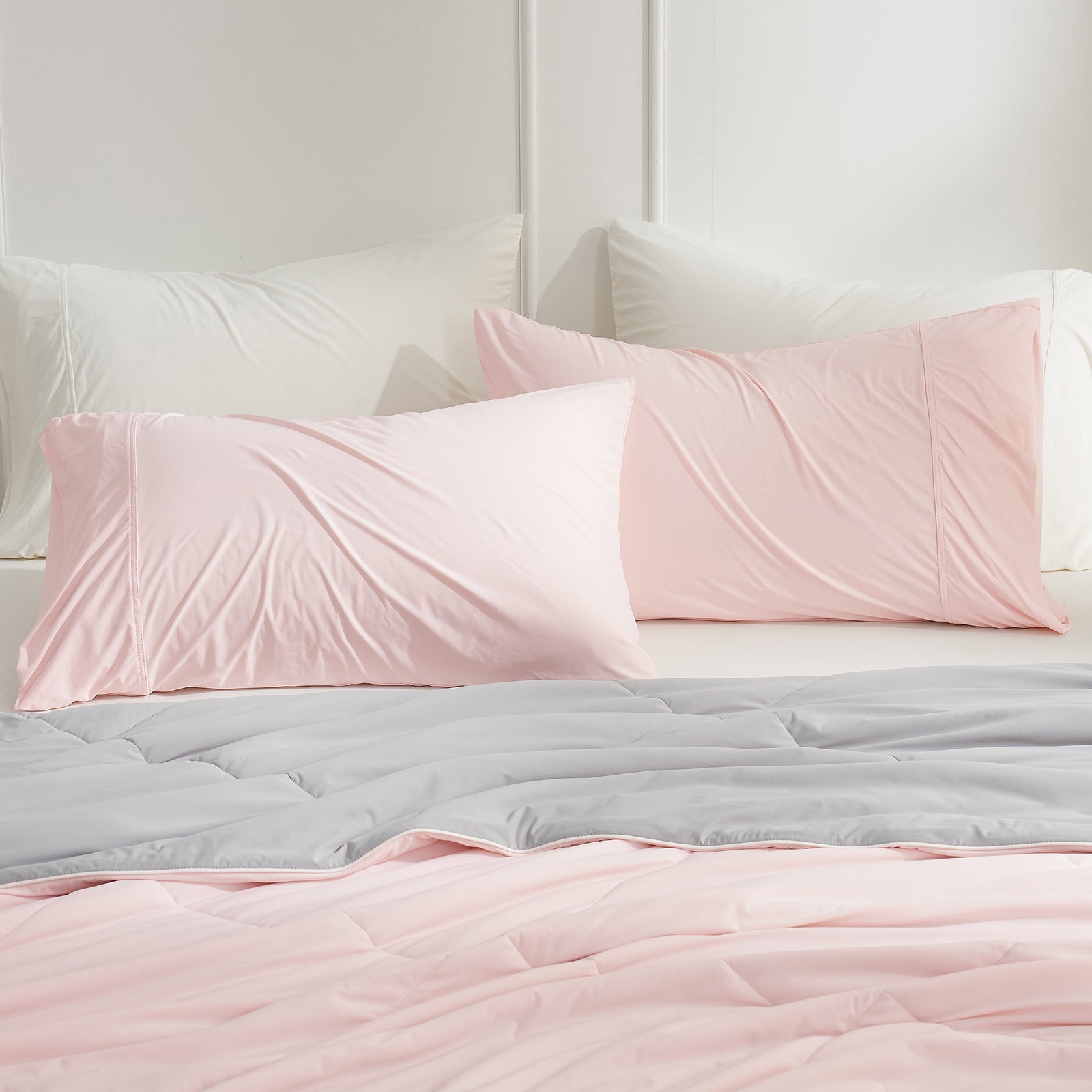 Pink cooling pillowcases on bed, part of a Cozybliss set for comfortable sleep, breathable bedding. #color_Pink