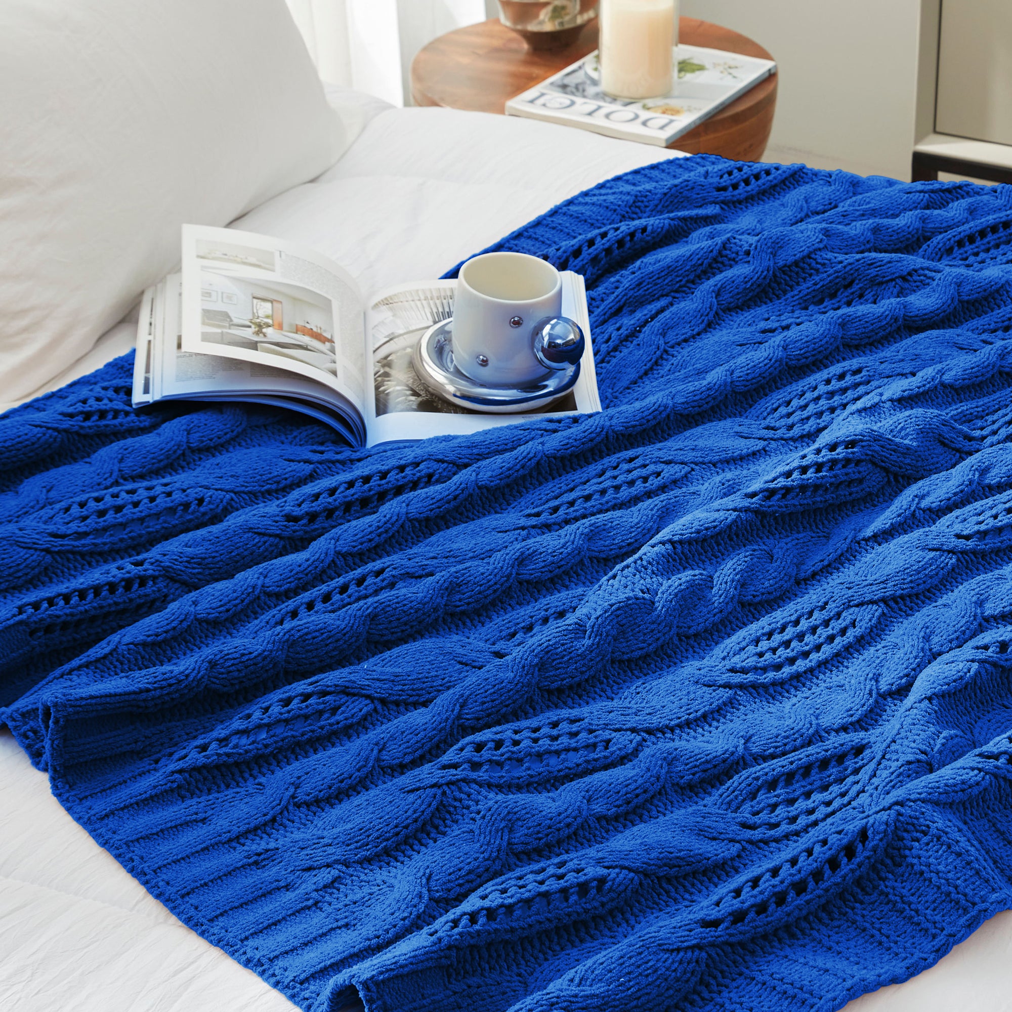 Chenille Cable Knit Throw Blanket in Blue styled on a bed in a cozy bedroom, adding a calm and stylish look. #color_Blue
