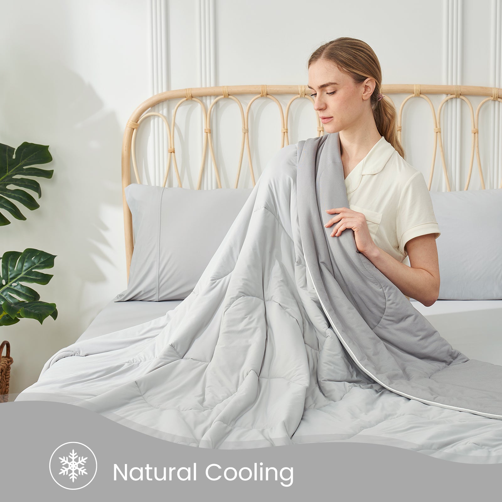 Woman with gray Cozy Bliss cooling comforter. Natural cooling and breathable design for hot sleepers. #color_Cool Grey