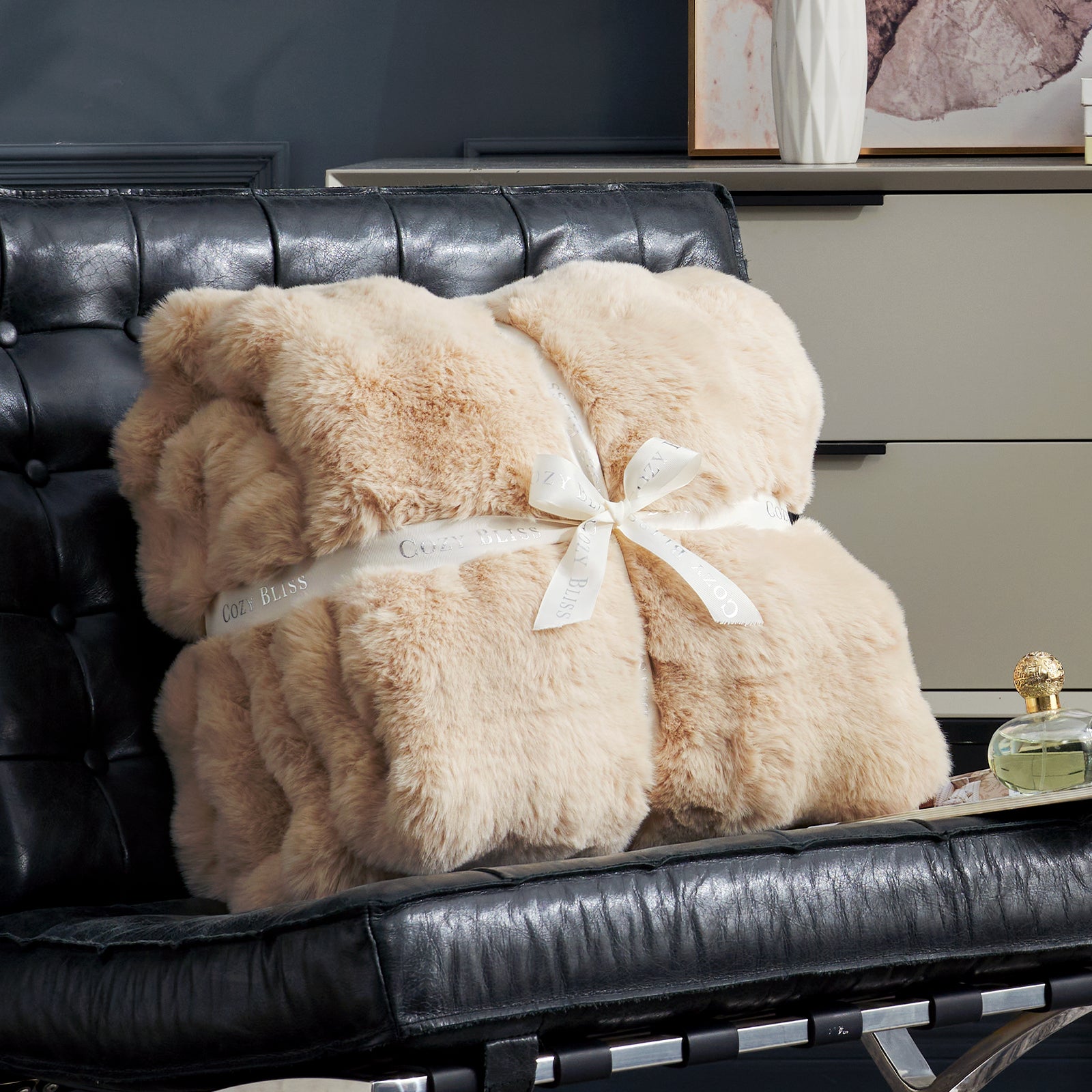 Cozy Bliss beige faux fur throw blanket on black leather chair, perfect for cozy comfort and style. #color_Beige