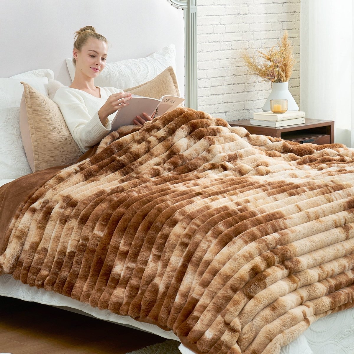Woman lying on a bed with a brown and brown blanket, reading a book. #Color_Tie-dye Brown