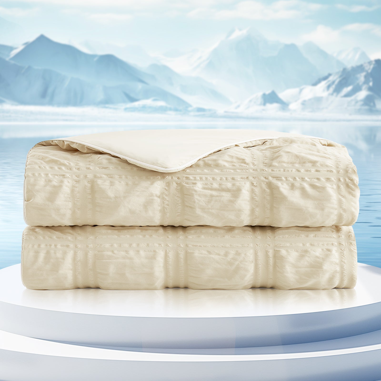 Folded beige blanket on a white platform with a mountainous landscape in the background #color_Khaki