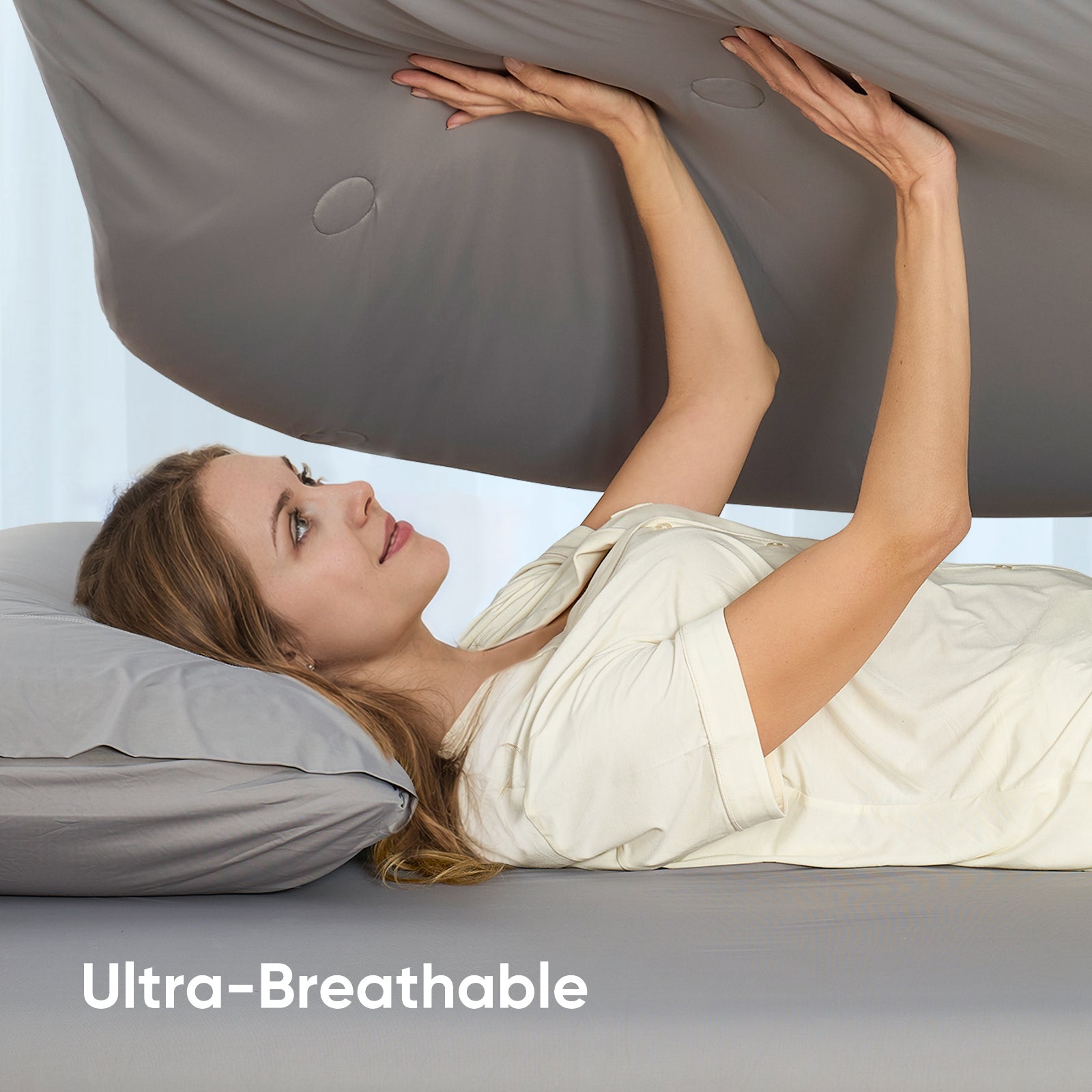 Women touching breathable cooling comforter.#color_Grey
