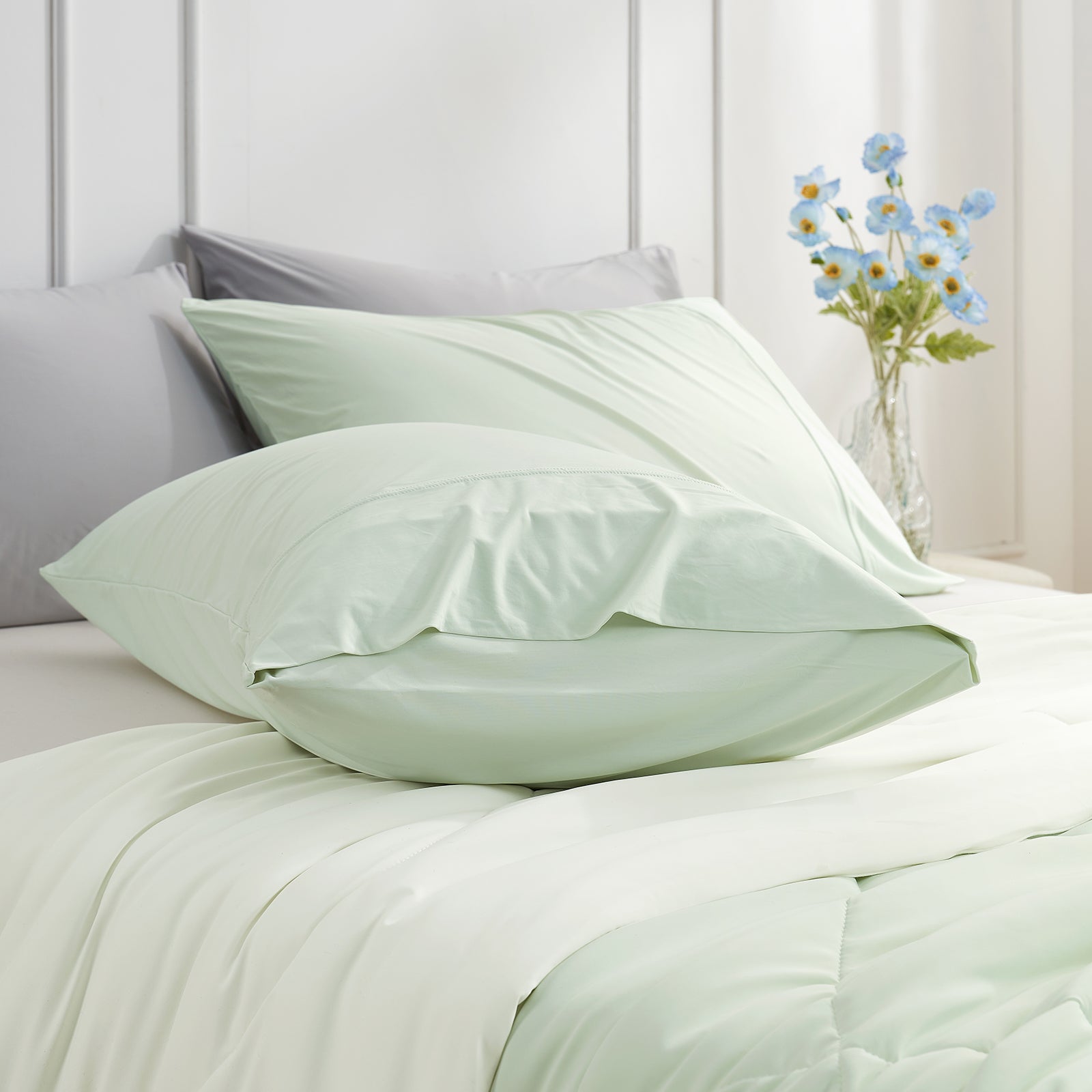 Cooling pillowcases in mint green on a bed. Breathable, soft bedding for comfortable sleep. #color_Green