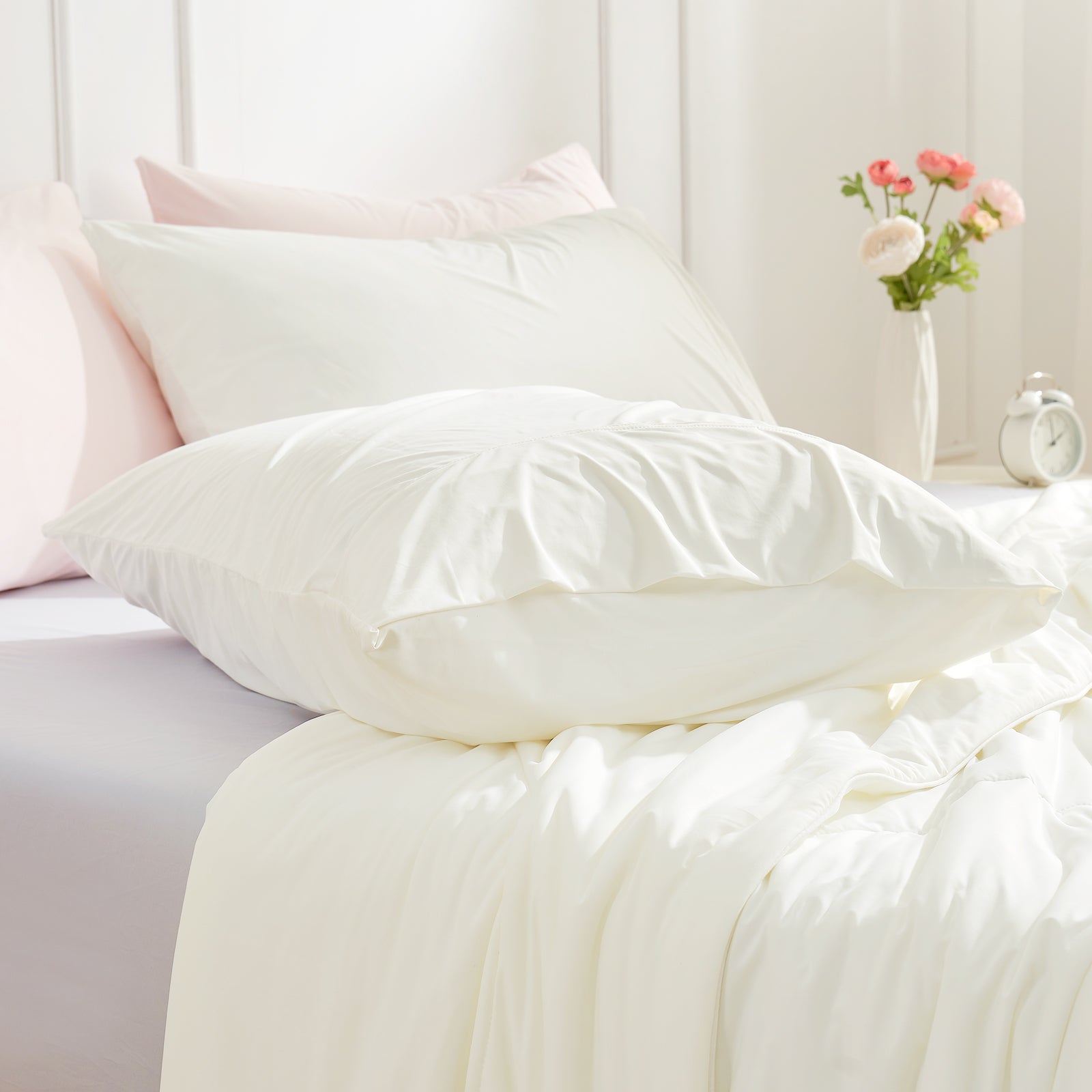 Ivory cooling pillowcases on bed, showcasing smooth, breathable fabric for summer comfort. #color_Off White
