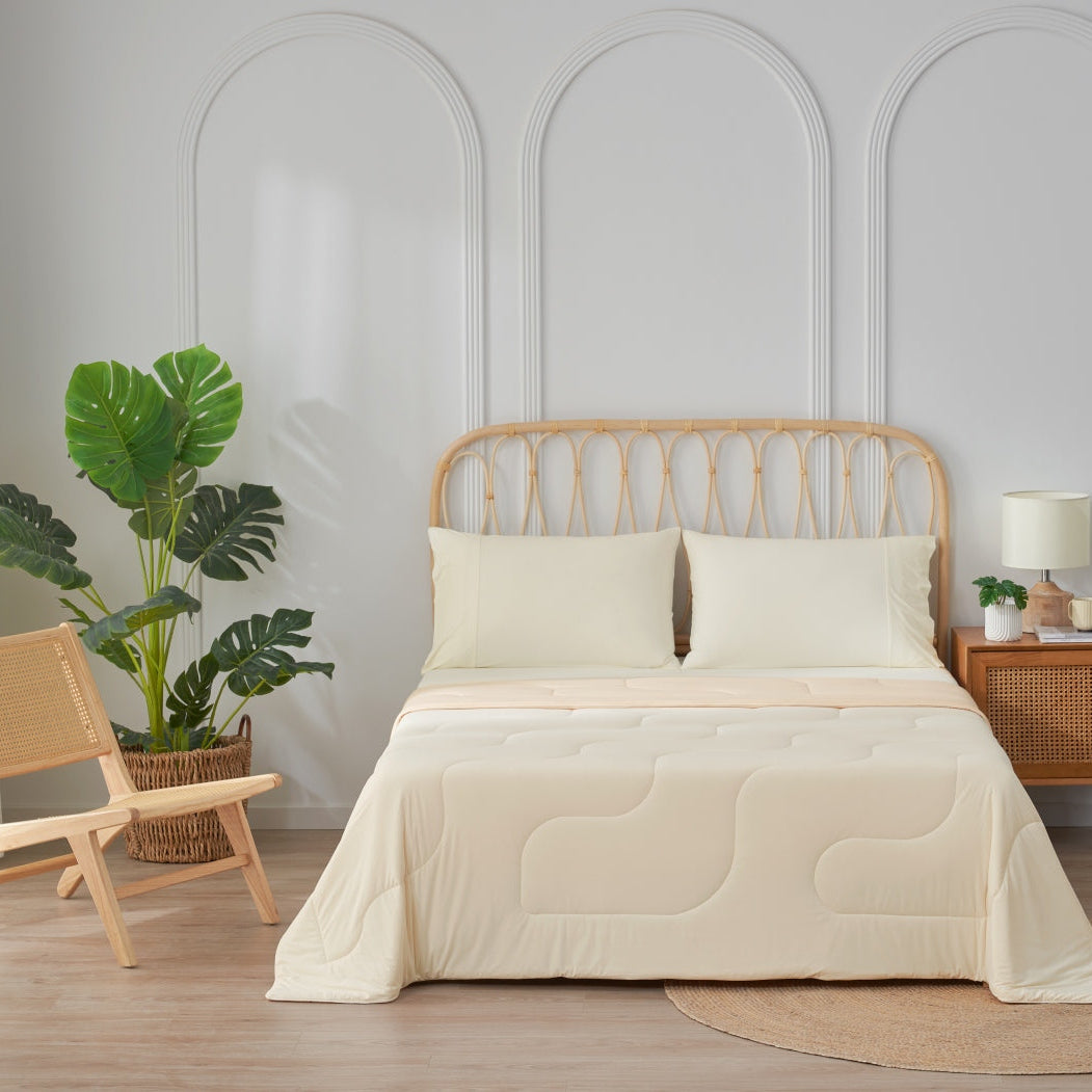 Bedroom with a bed covered in beige bedding, a wooden chair, and plants. #Color_Cream White