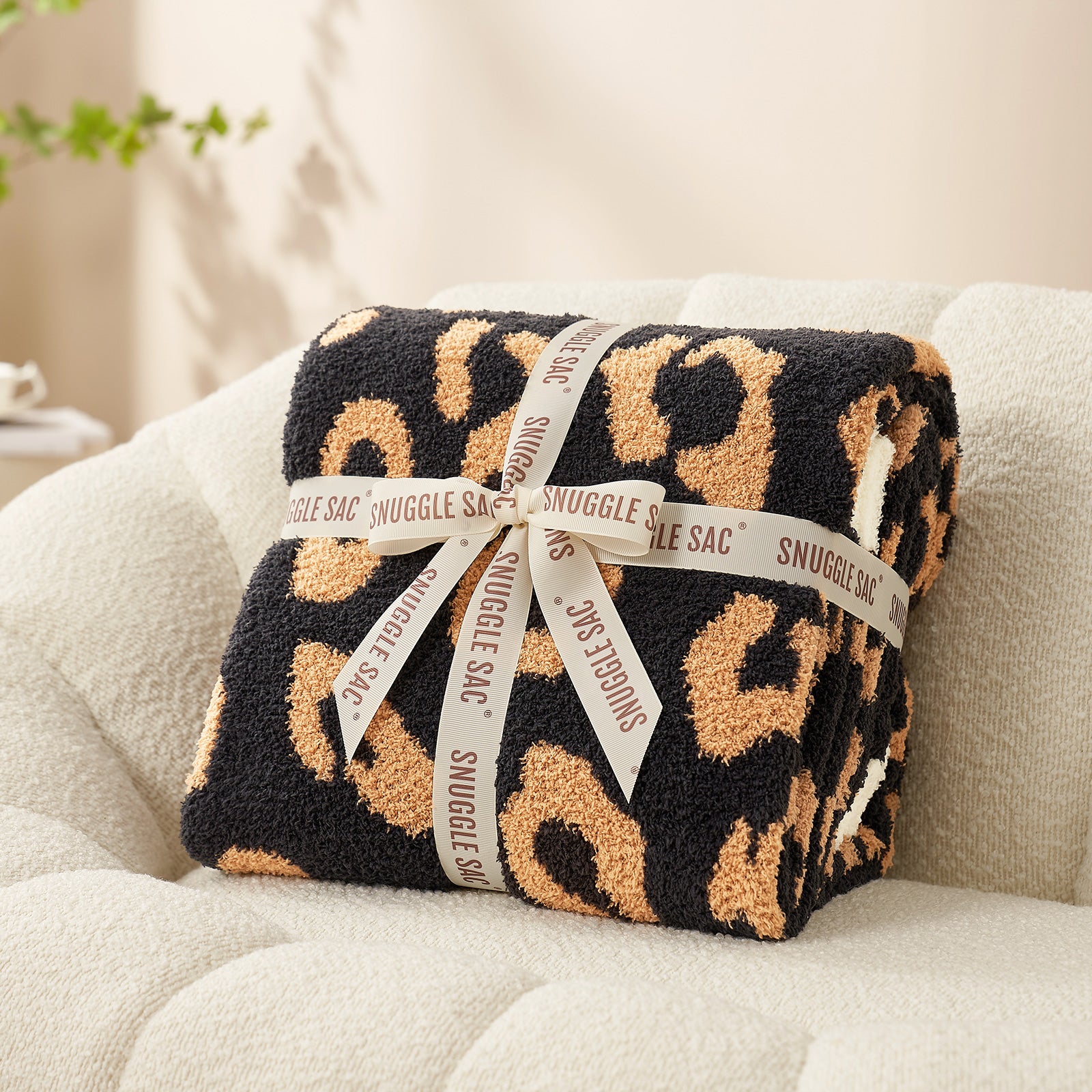 Reversible Leopard Feather Yarn Throw Blanket in Brown Leopard neatly folded with ribbon, perfect as a cozy gift option. #color_Brown Leopard