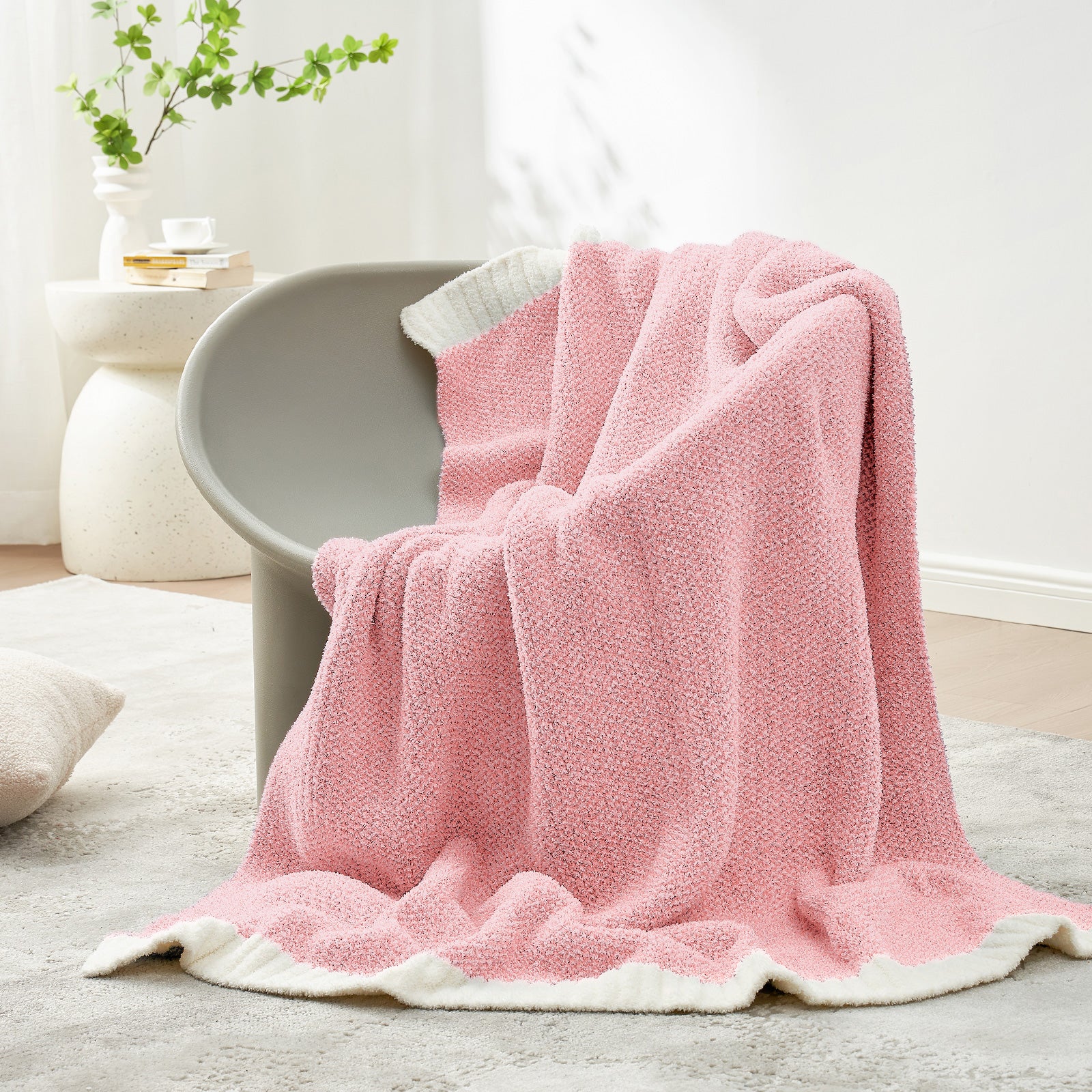 Heather Feather Yarn Throw Blanket in Pink draped over a chair, adding a soft cozy touch. #Color_Pink