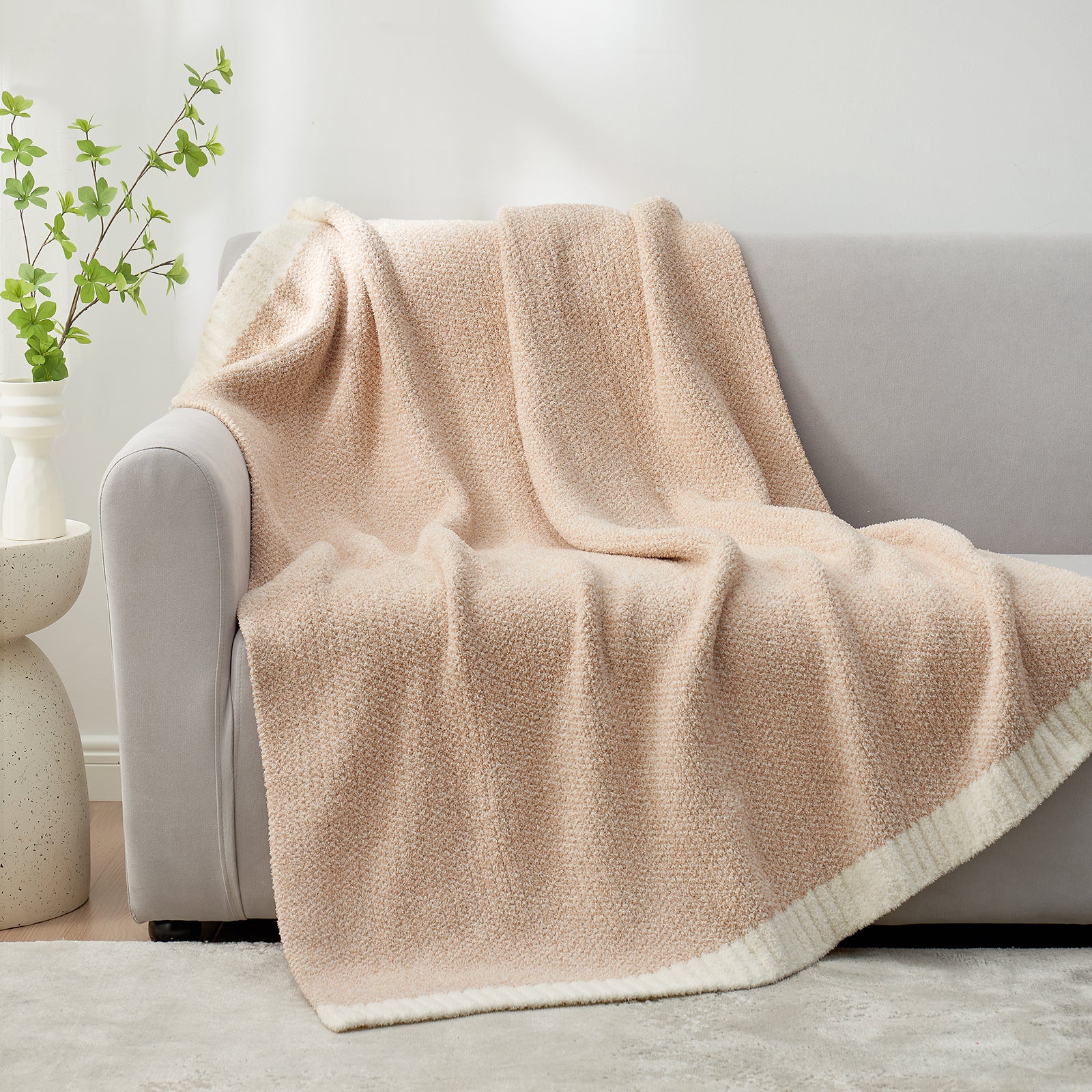 Heather Feather Yarn Throw Blanket in beige draped over a sofa, adding warmth, softness and a modern cozy touch to your living room. #color_Beige