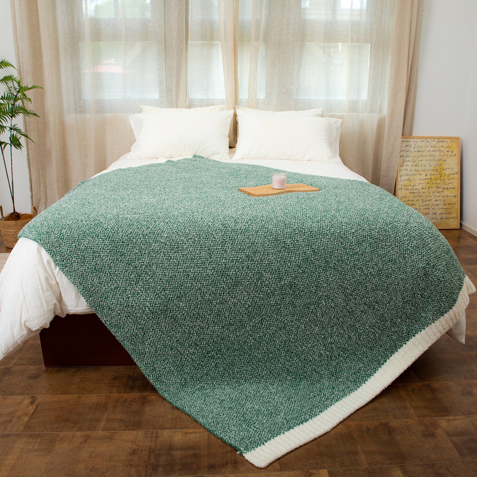 Heather Feather Yarn Throw Blanket in heather green styled on a bed, enhancing bedroom decor with a soft, elegant and cozy layered look. #Color_Heather Green