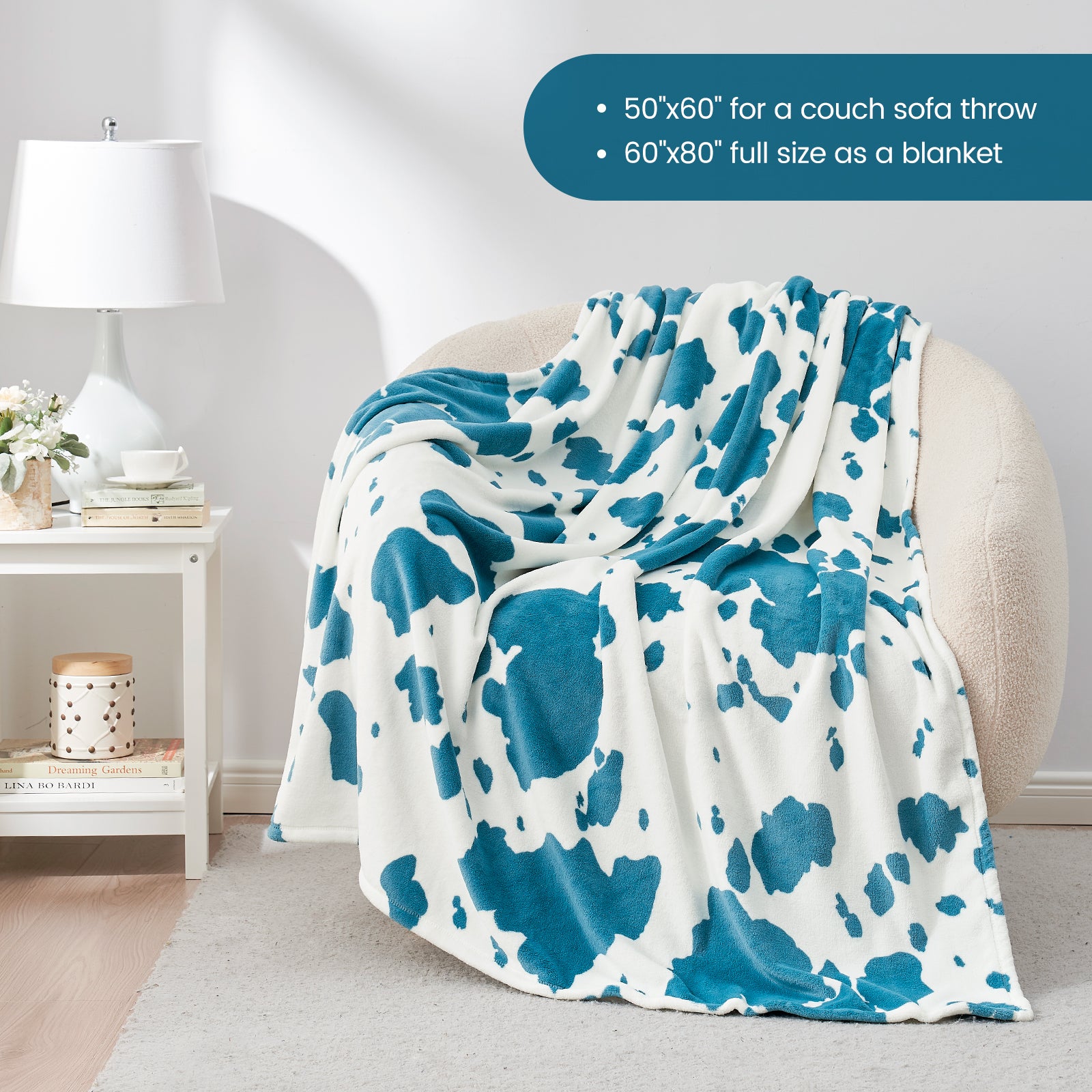 Blue and white patterned throw blanket draped over a chair in a room with a lamp and small table.  #color_Blue