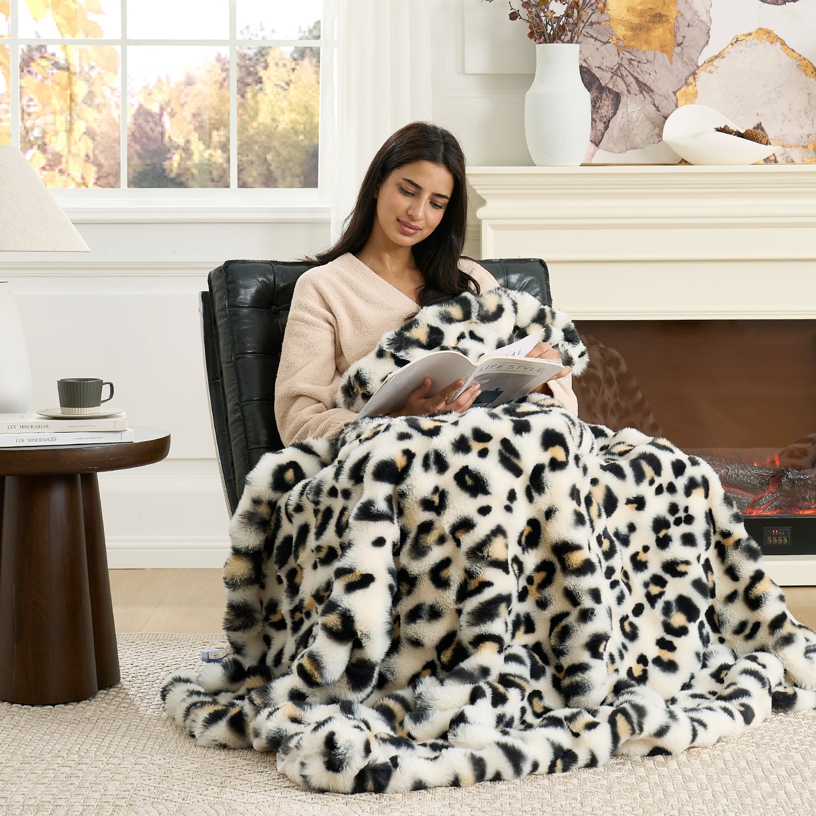 Woman reading a book under a leopard print blanket in a cozy living room. #Color_Leopard