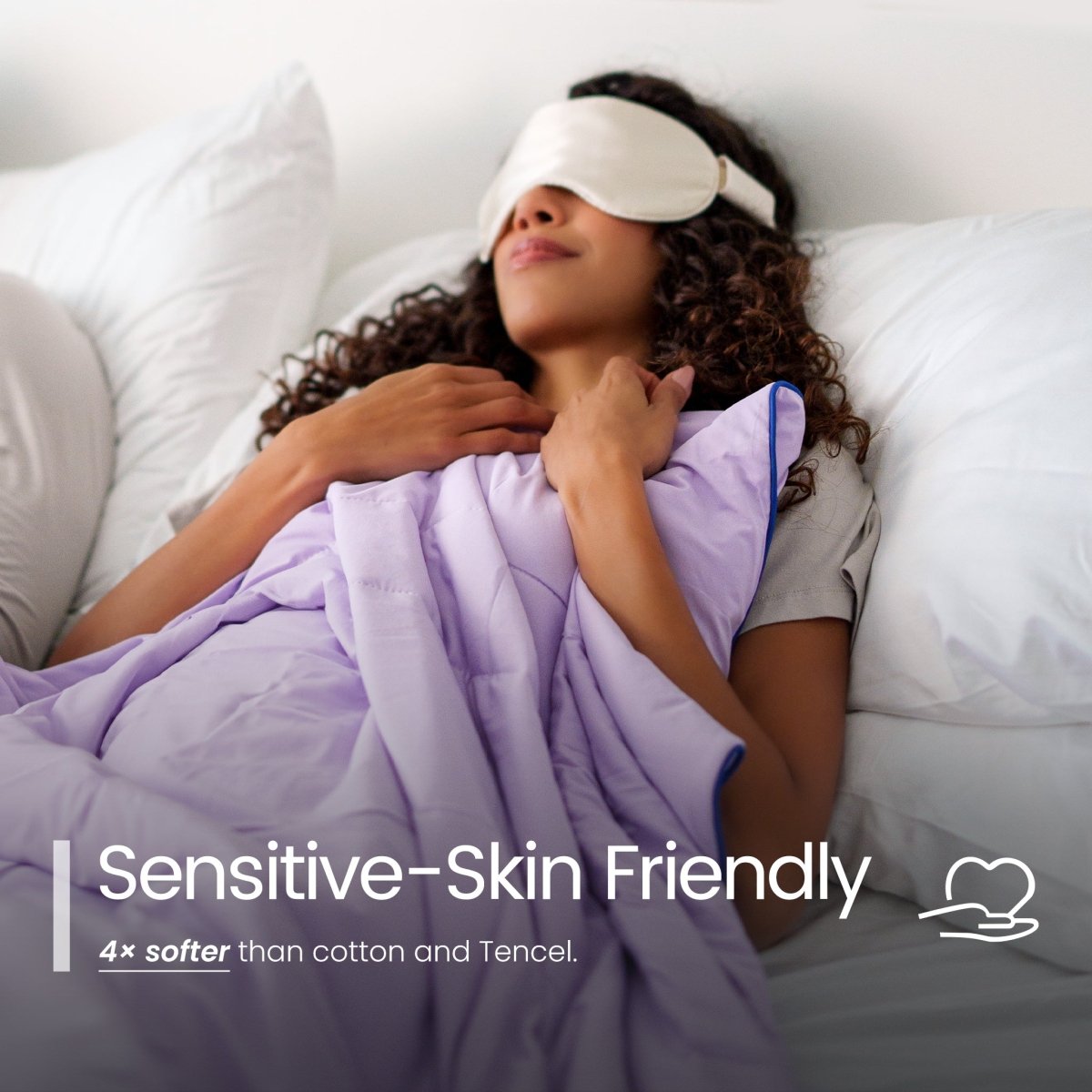 Woman lying in bed with a purple cooling comforter and sleep mask, with text indicating 'Sensitive-Skin Friendly'.#color_Purple