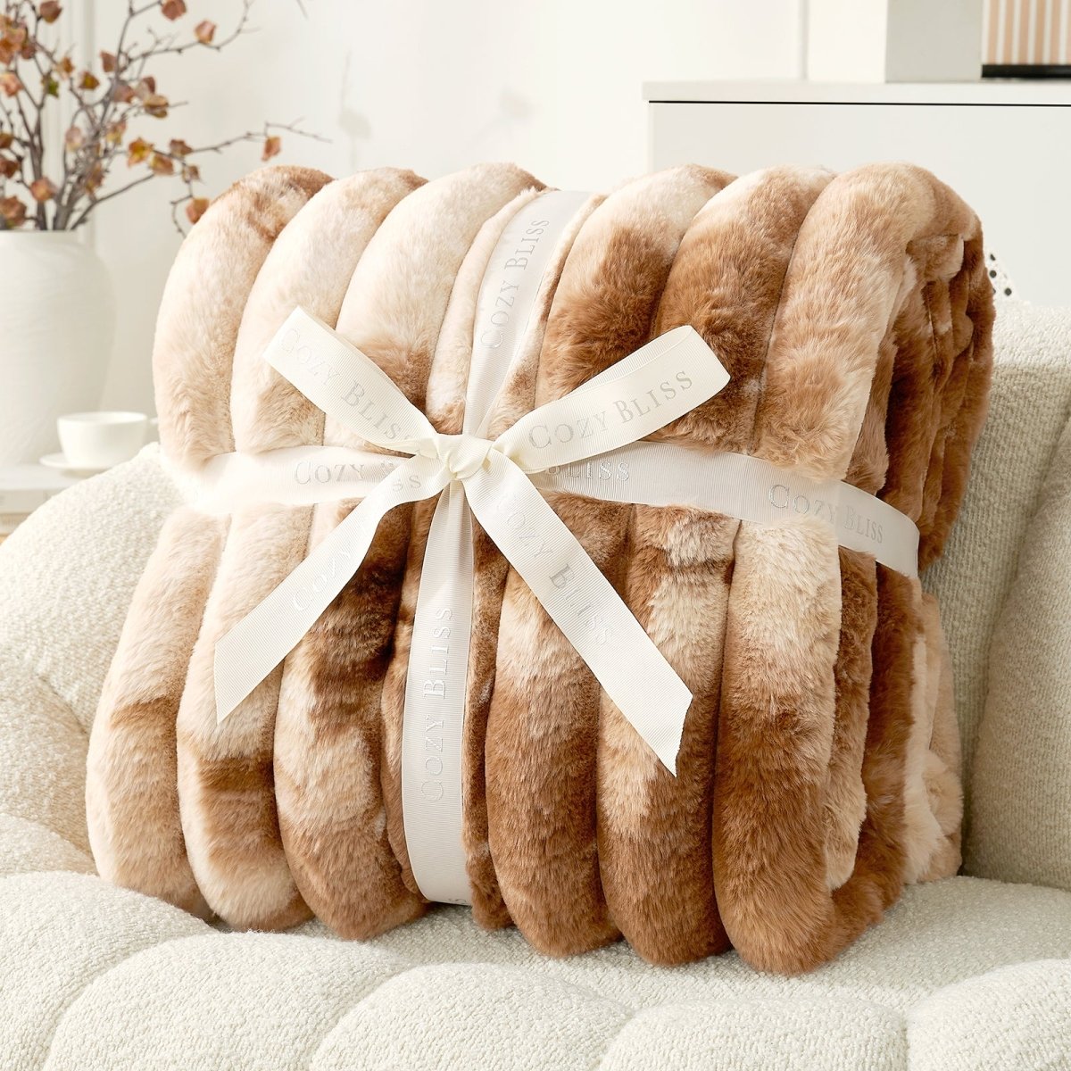 Brown plush blanket with a white ribbon on a white surface. #Color_Tie-dye Brown