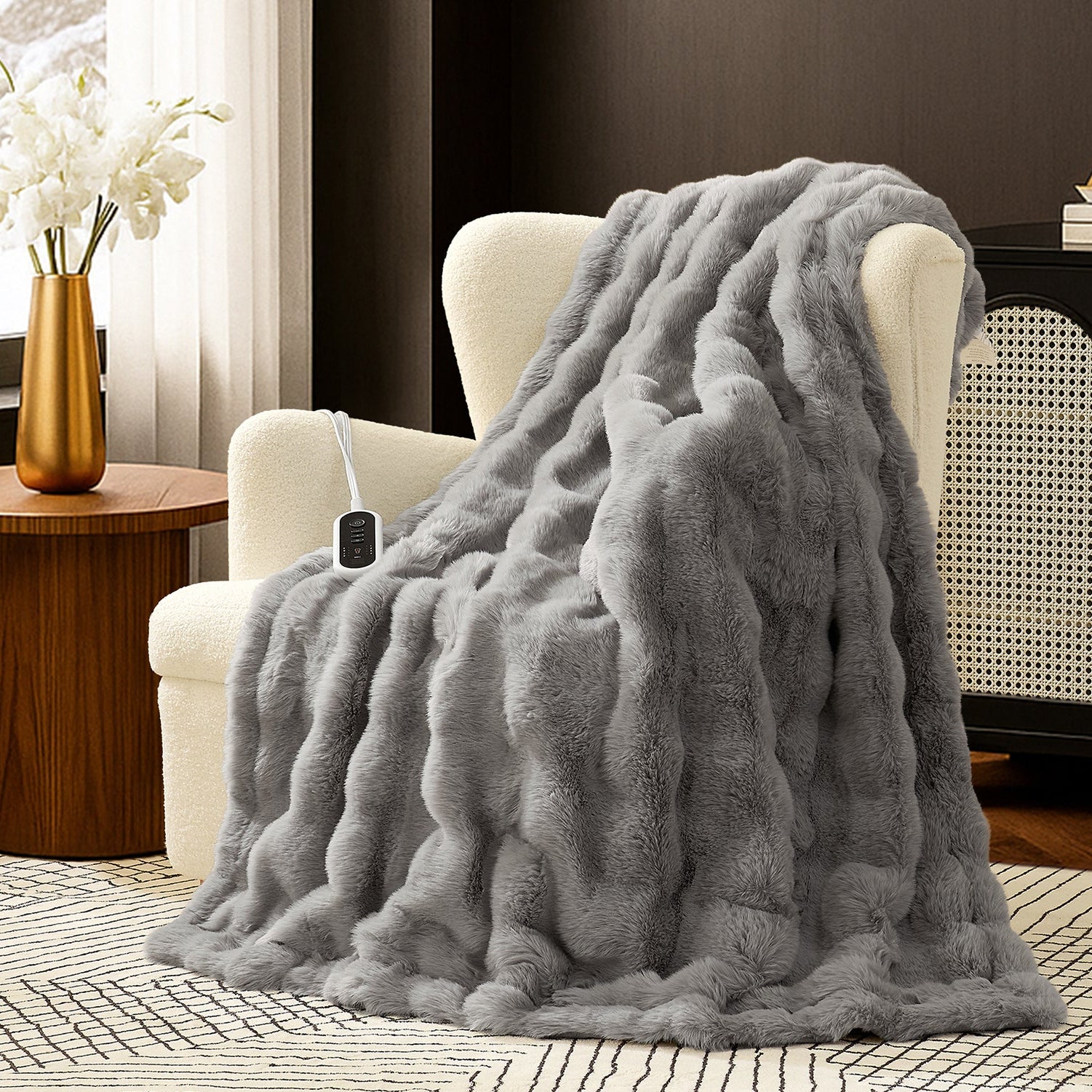 Woman sitting on a couch with a gray fuzzy blanket wrapped around her, using a laptop. #color_Light Grey