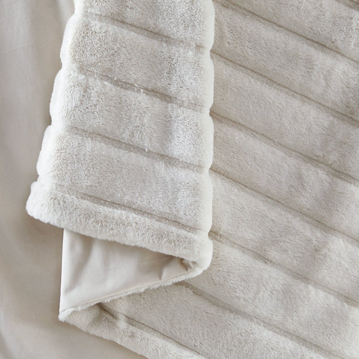 Close-up of Cozy Bliss faux fur blanket texture with ultra-soft hand feel #color_Ivory