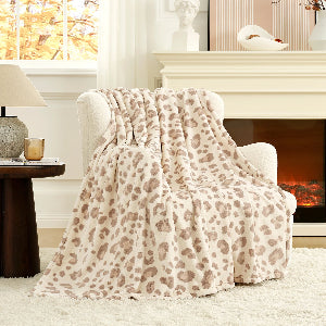 Leopard print blanket draped over a chair in a cozy living room with a fireplace.