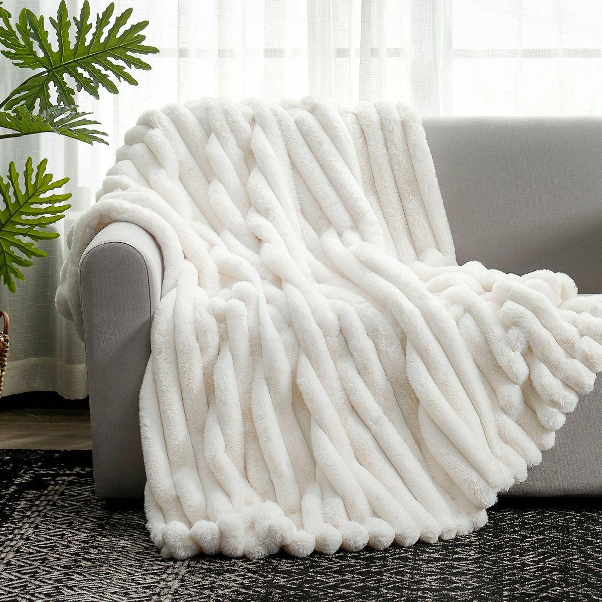 Cozy Bliss Ultra Chunky Striped Faux Fur Throw Blanket in Cream White styled on a sofa. #color_Cream White