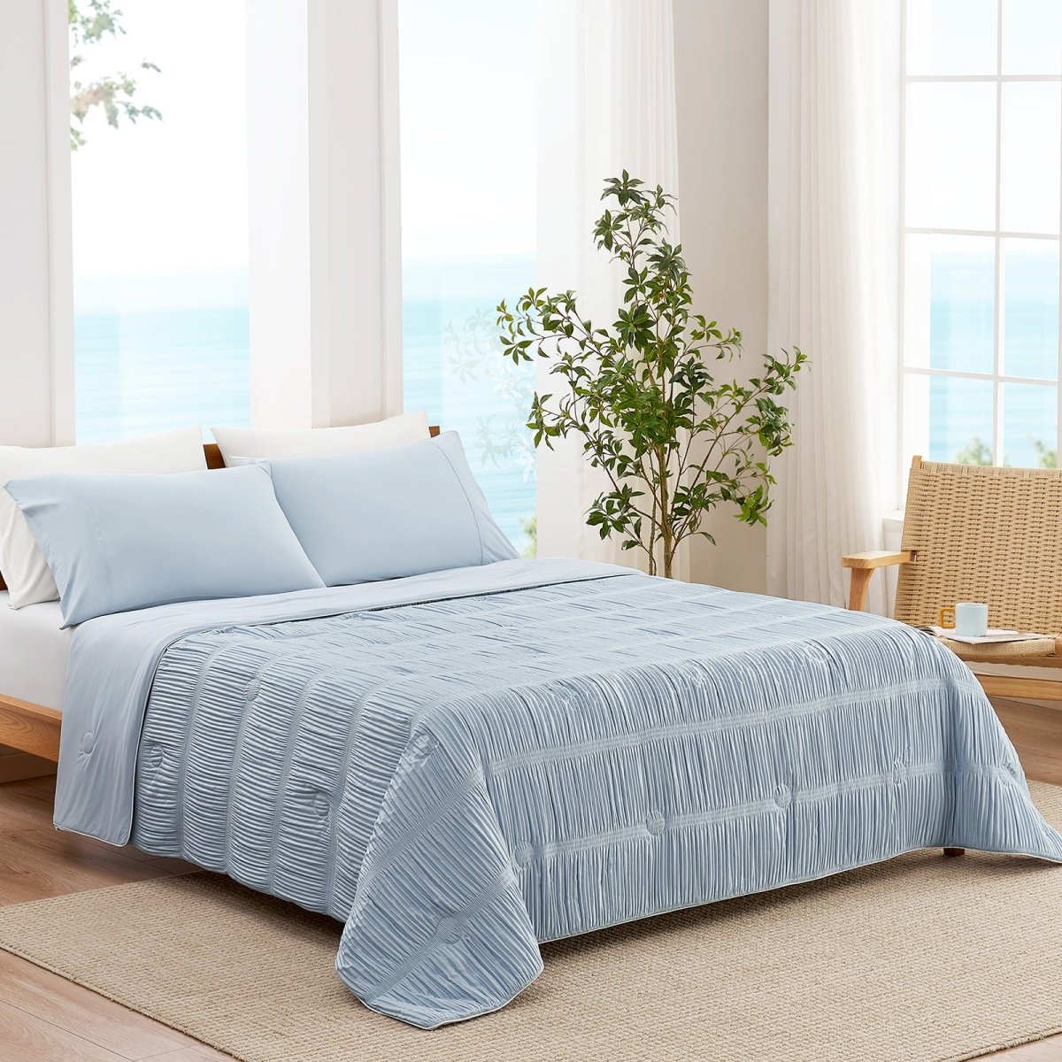 Blue striped cooling comforter on bed in bright coastal bedroom, breathable lightweight bedding with textured fabric.#color_Cool Blue