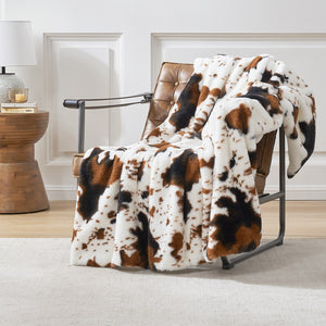 Cow print faux fur blanket draped over leather chair; cozy and stylish home decor #color_Black/Brown
