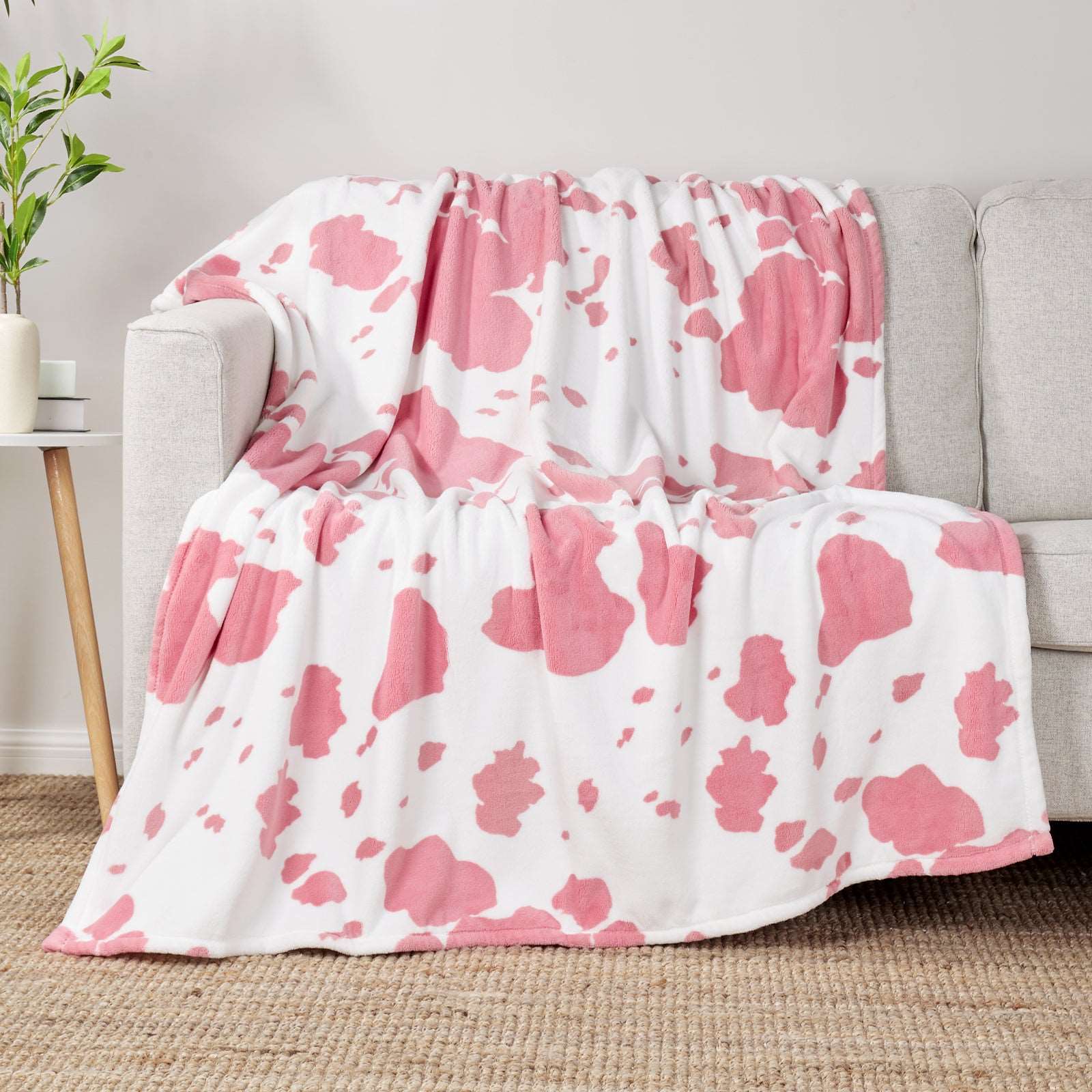 Pink cow print blanket on a white couch #color_Strawberry