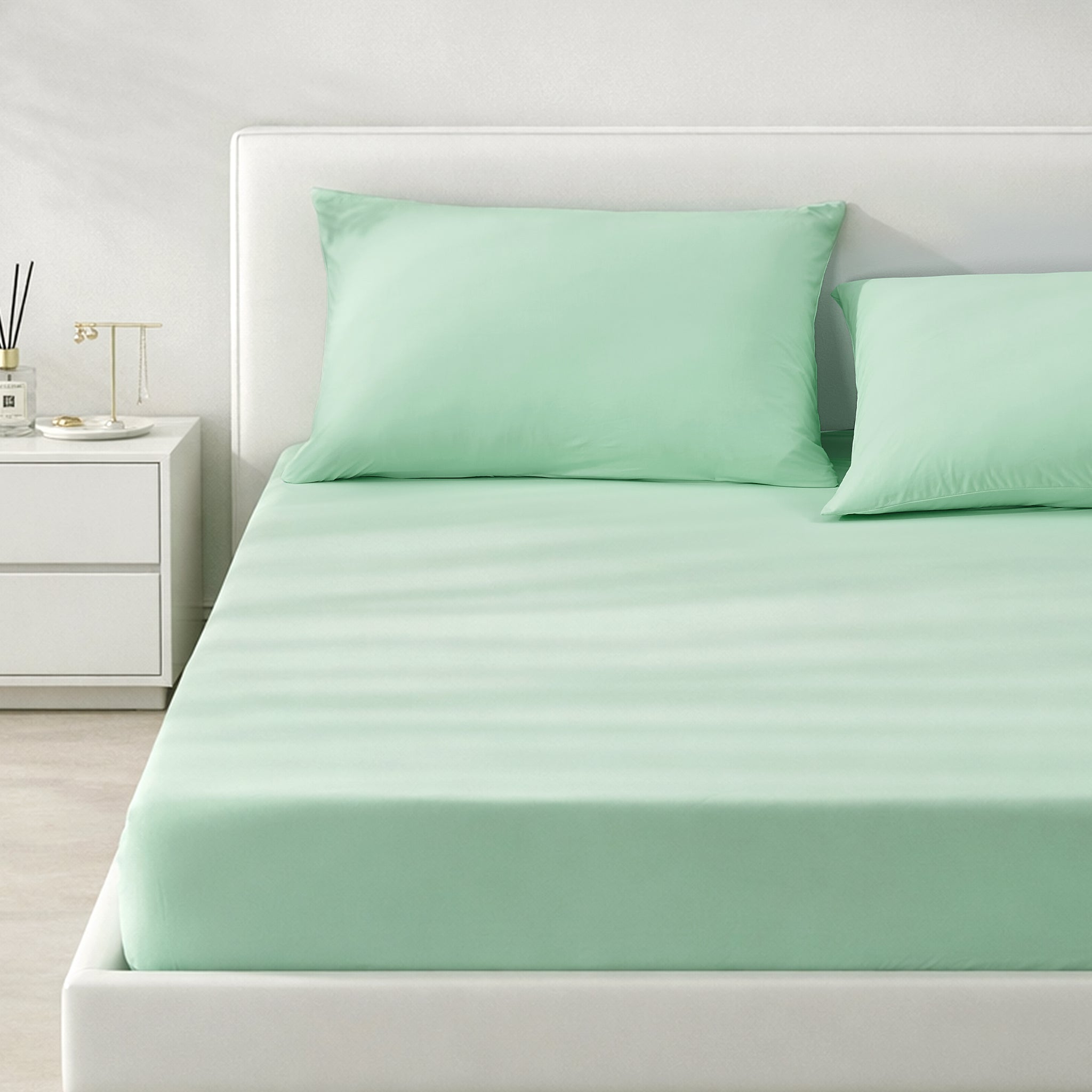 Green cooling bedding set on a bed in a minimalistic bedroom setting.#color_Mint Macaron