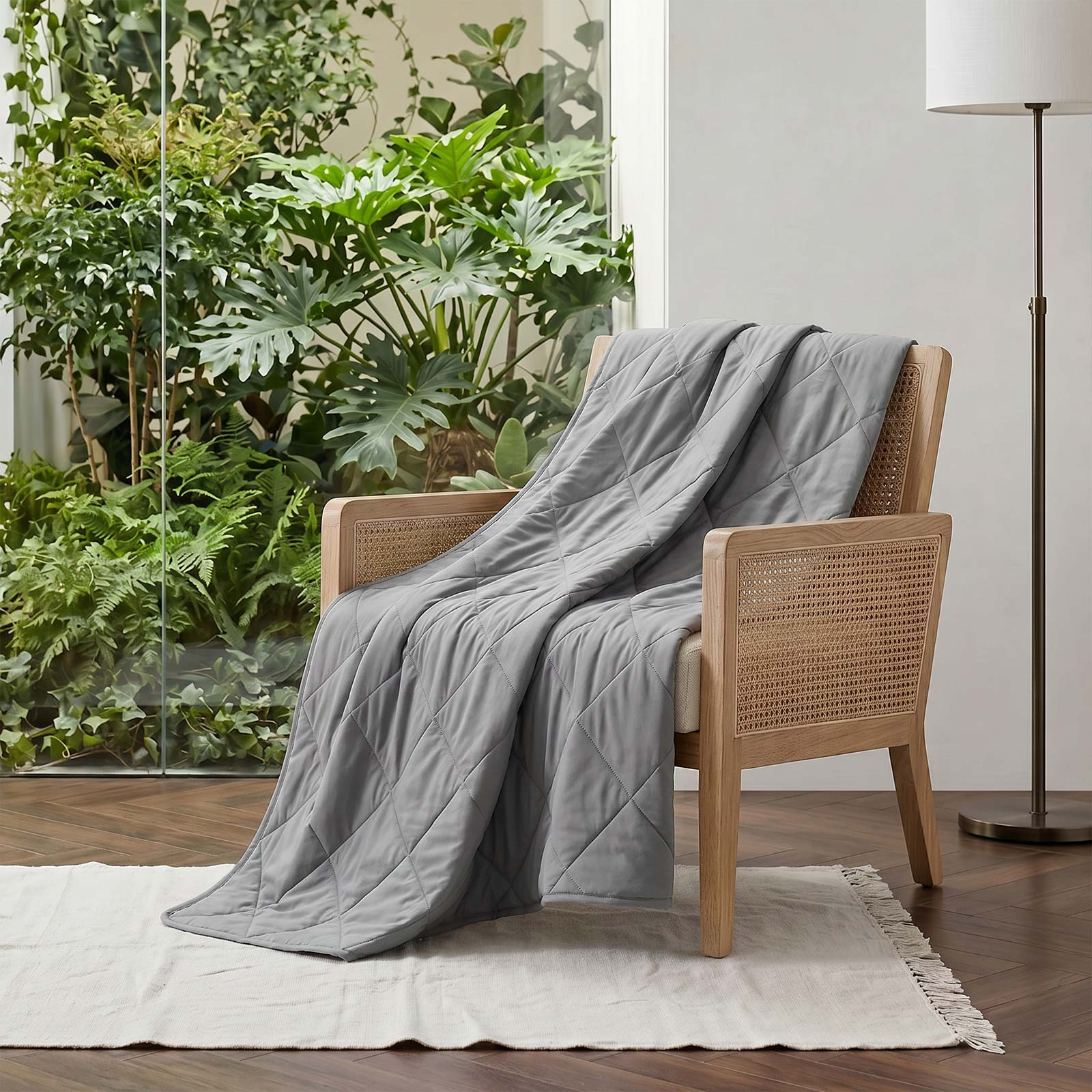 Cozy Bliss Dark Grey cooling blanket draped over a beige sofa. #color_Dark Grey