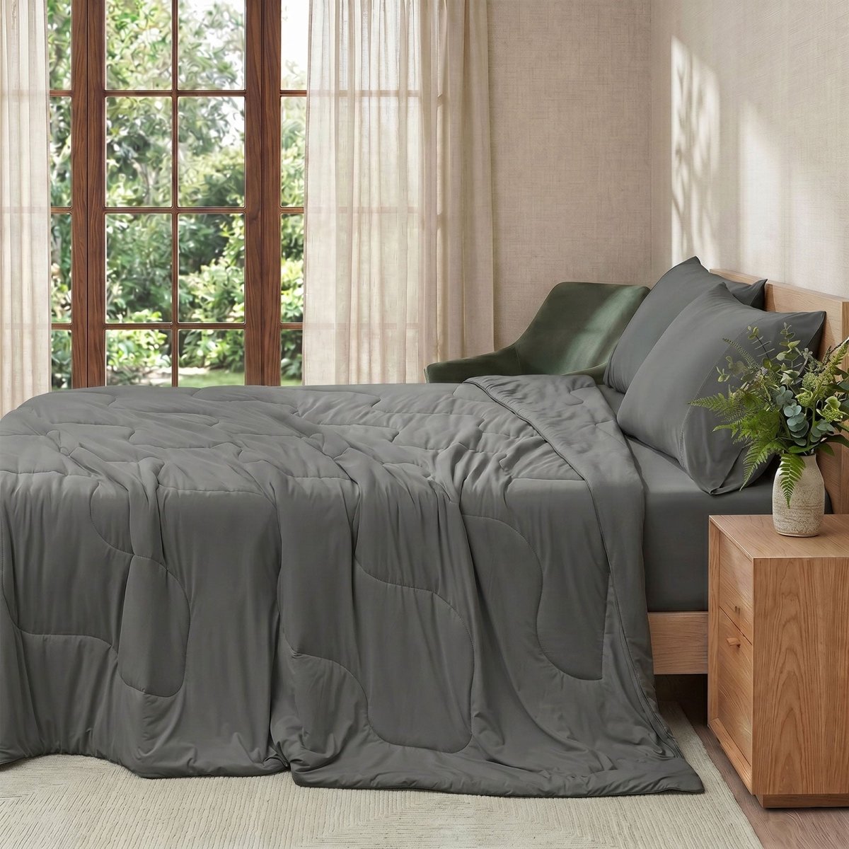 Cozy Bliss natural fiber cooling comforter on a bed in side view.#color_Charcoal Grey