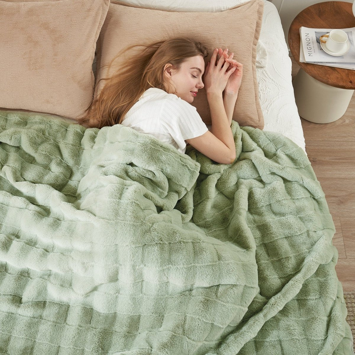 Woman sleeping under Cozy Bliss sage green faux fur blanket on bed, cozy bedding. #color_Sage Green