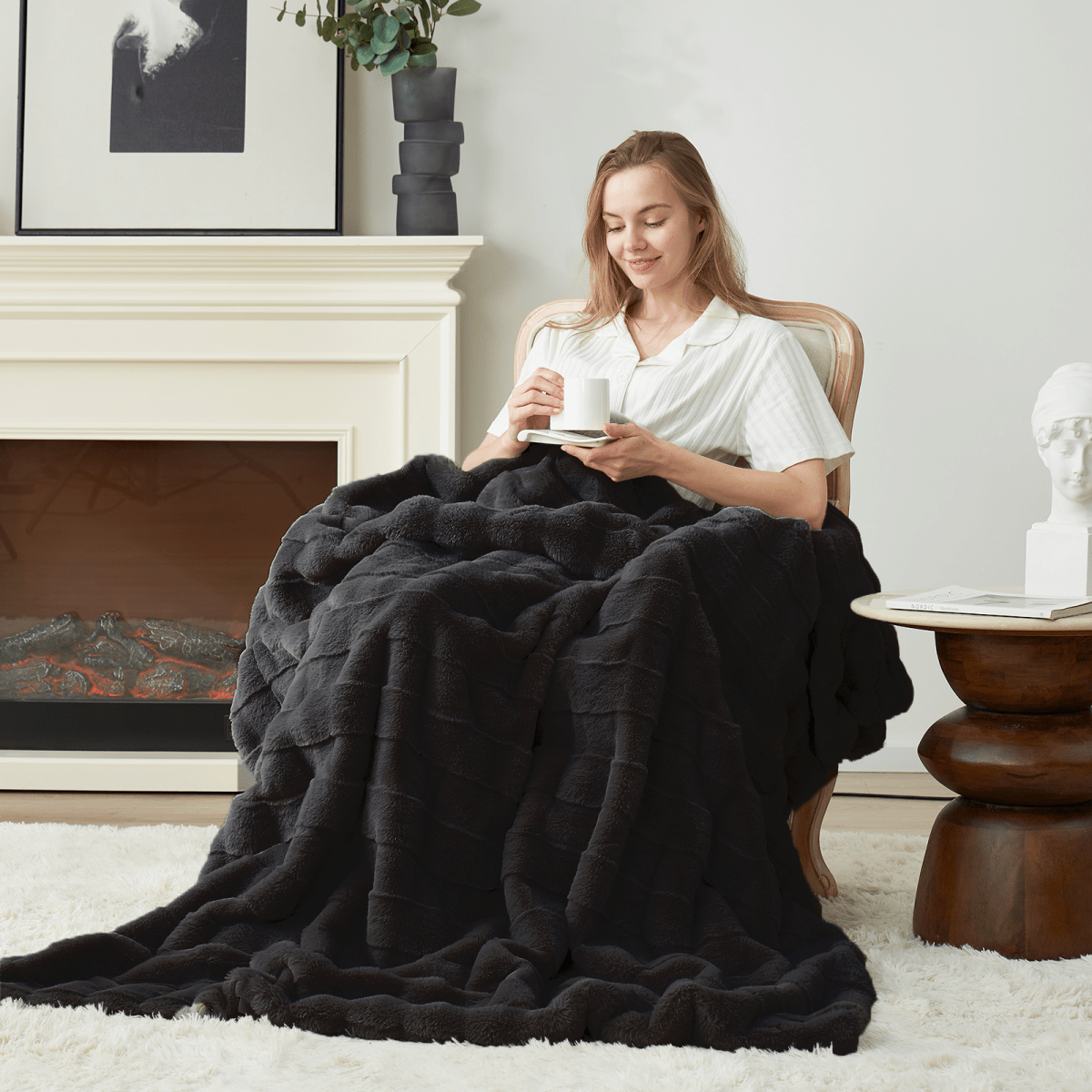Woman sitting in a chair with a cross-striped faux fur throw blanket.#Color_Black