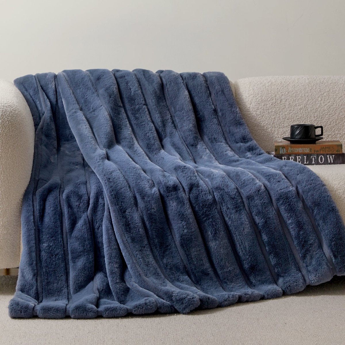 Cozy Bliss sheared faux fur throw blanket draped over a sofa, showcasing elegant ribbed texture #color_Navy Blue