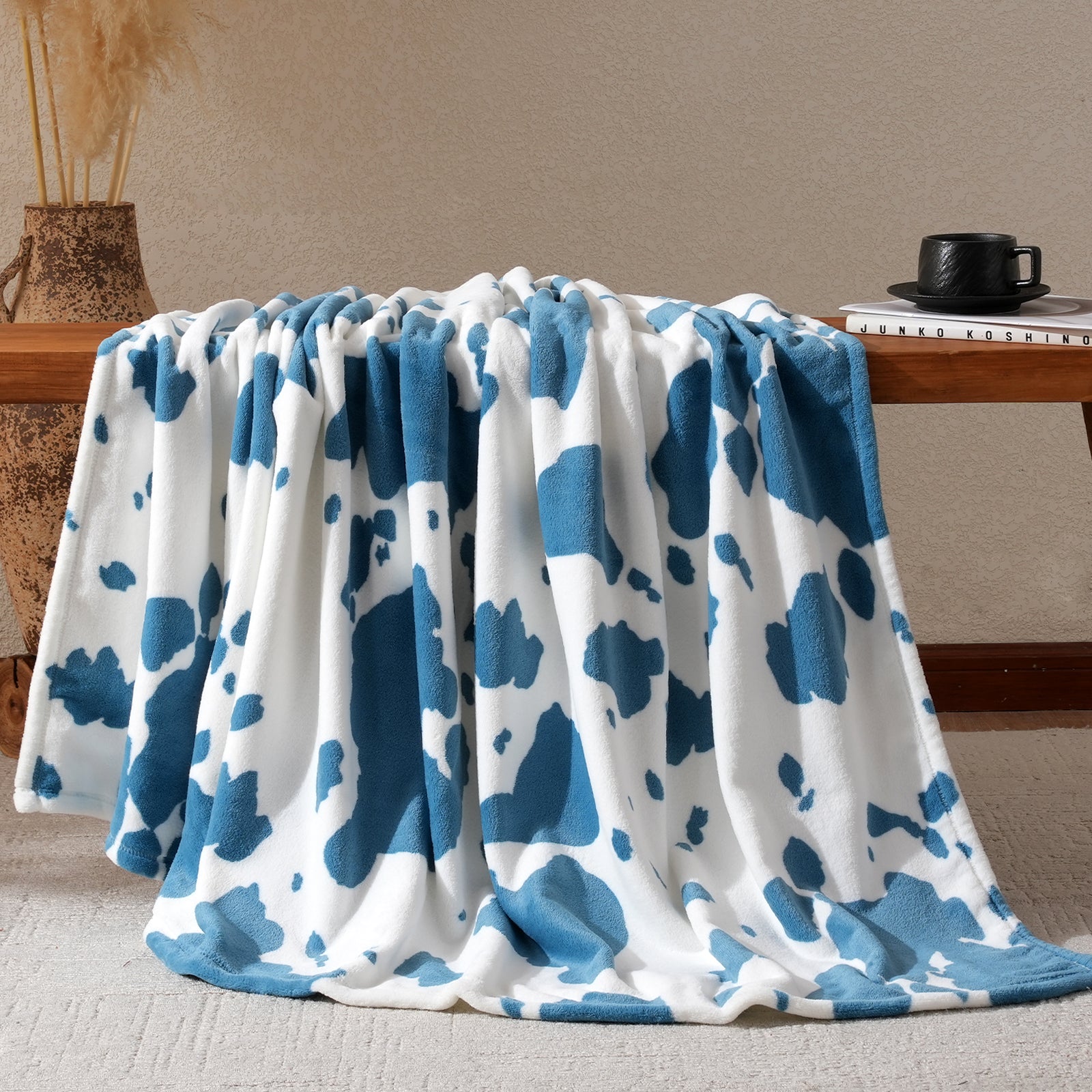 Blue and white patterned blanket draped over a wooden surface with a neutral background #color_Blue