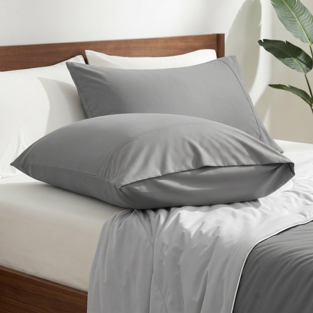Cozy Bliss envelope cooling pillowcases on bed.#color_Dark Grey