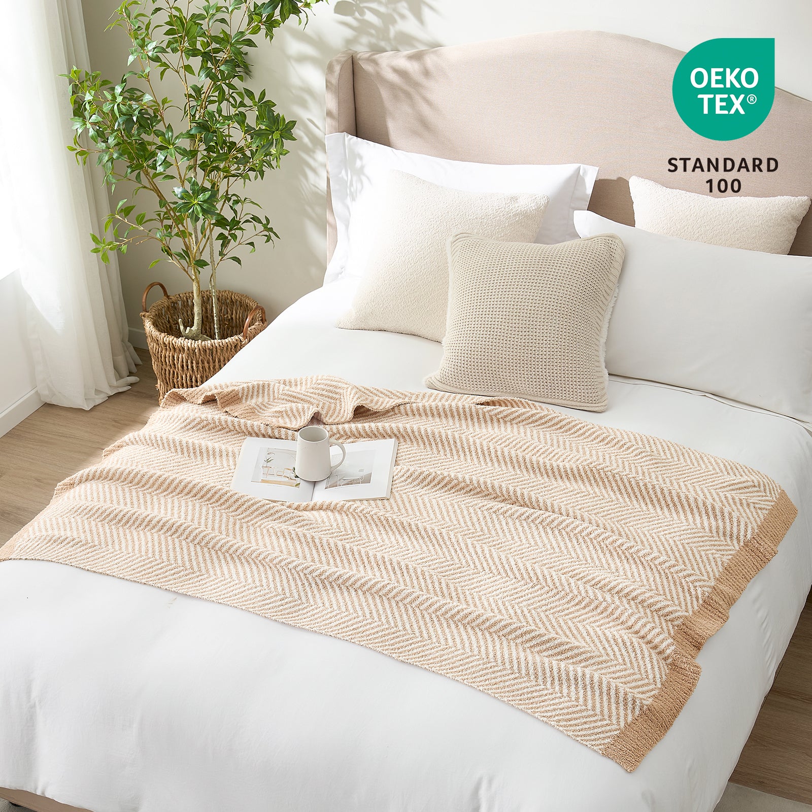 OEKO-TEX STANDARD 100 certified herringbone knit throw blanket styled on a white bed #color_Beige