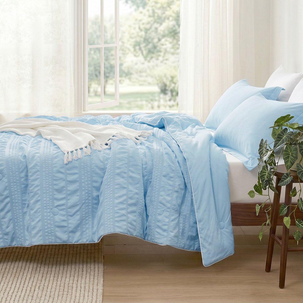 Cozy Bliss seersucker cooling comforter on bed in side view.#color_Sky Blue