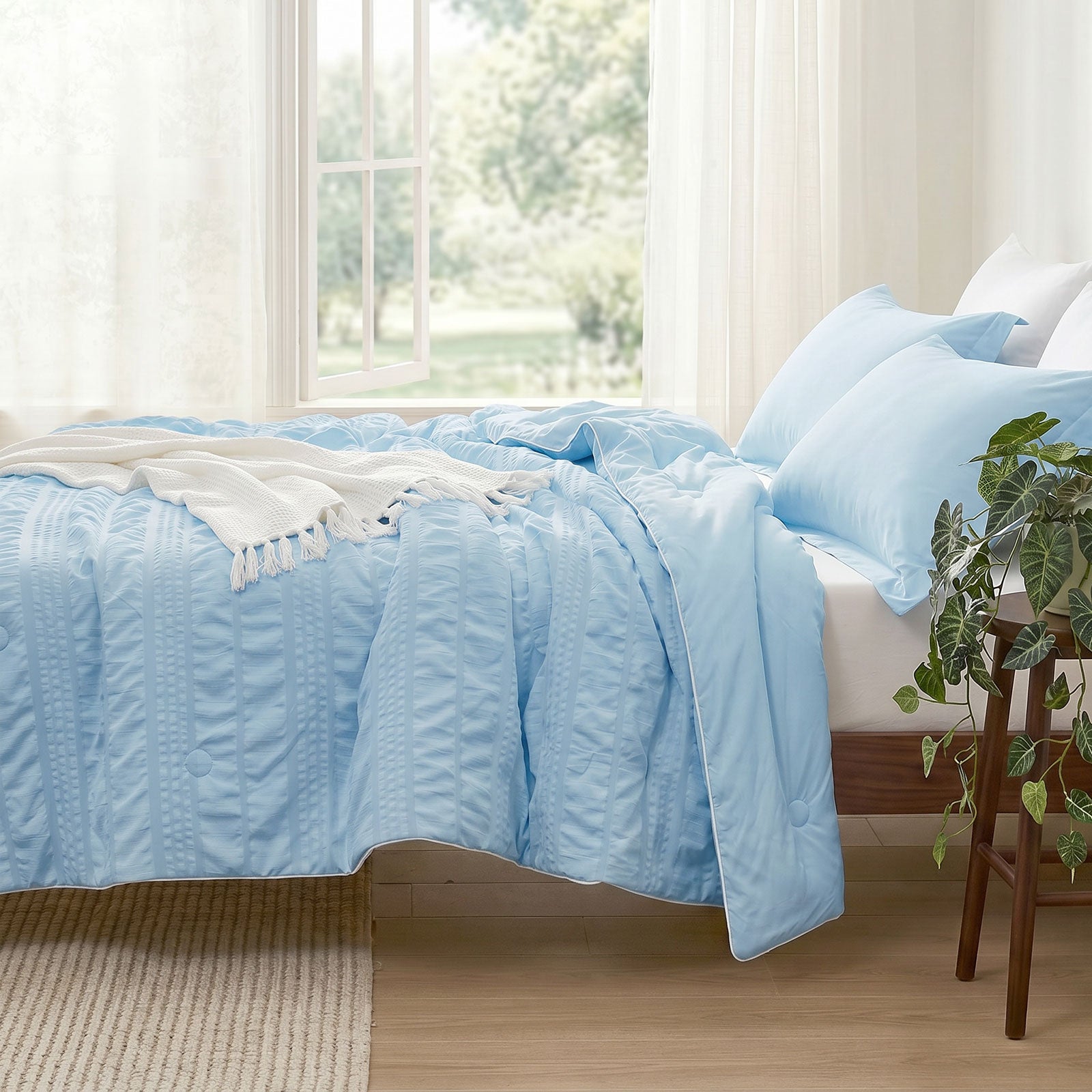 Cozy Bliss seersucker cooling comforter on bed in side view.#color_Sky Blue