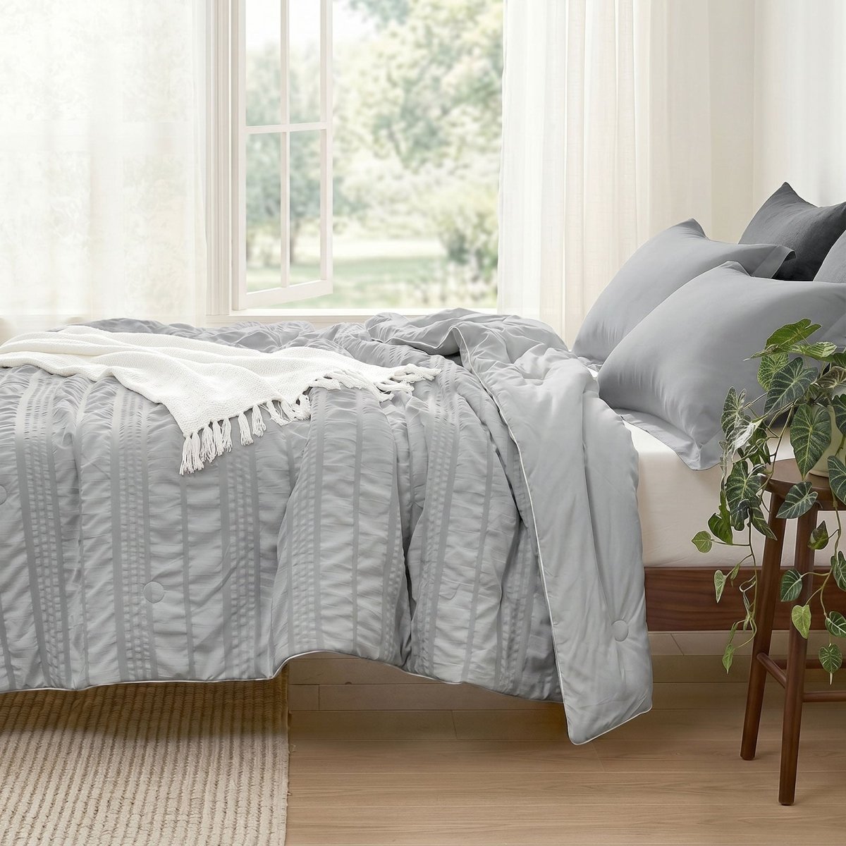Cozy Bliss seersucker cooling comforter on bed in side view.#color_Light Grey