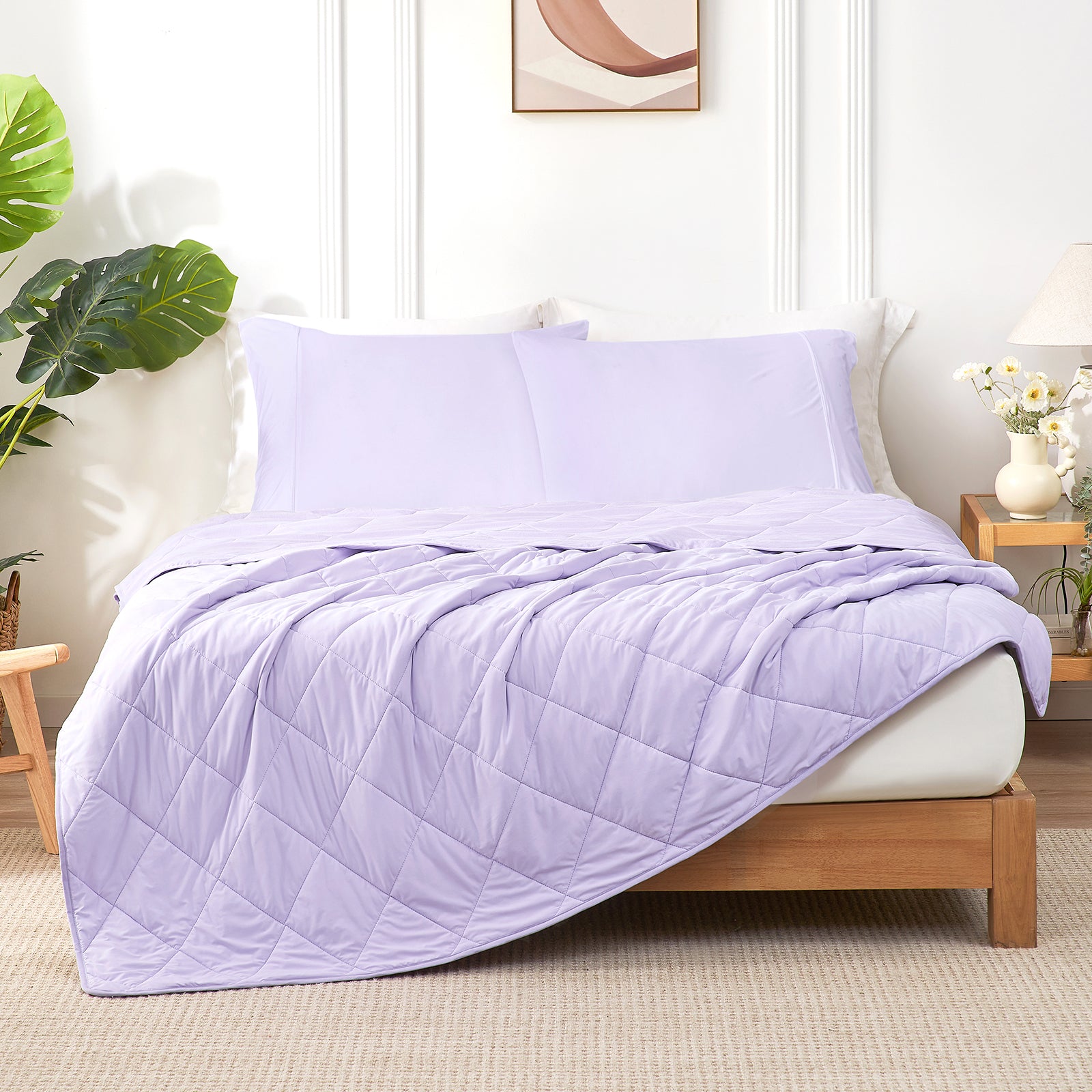 Purple quilt and pillow on a bed in a bedroom setting with plants and decor.  #color_Purple