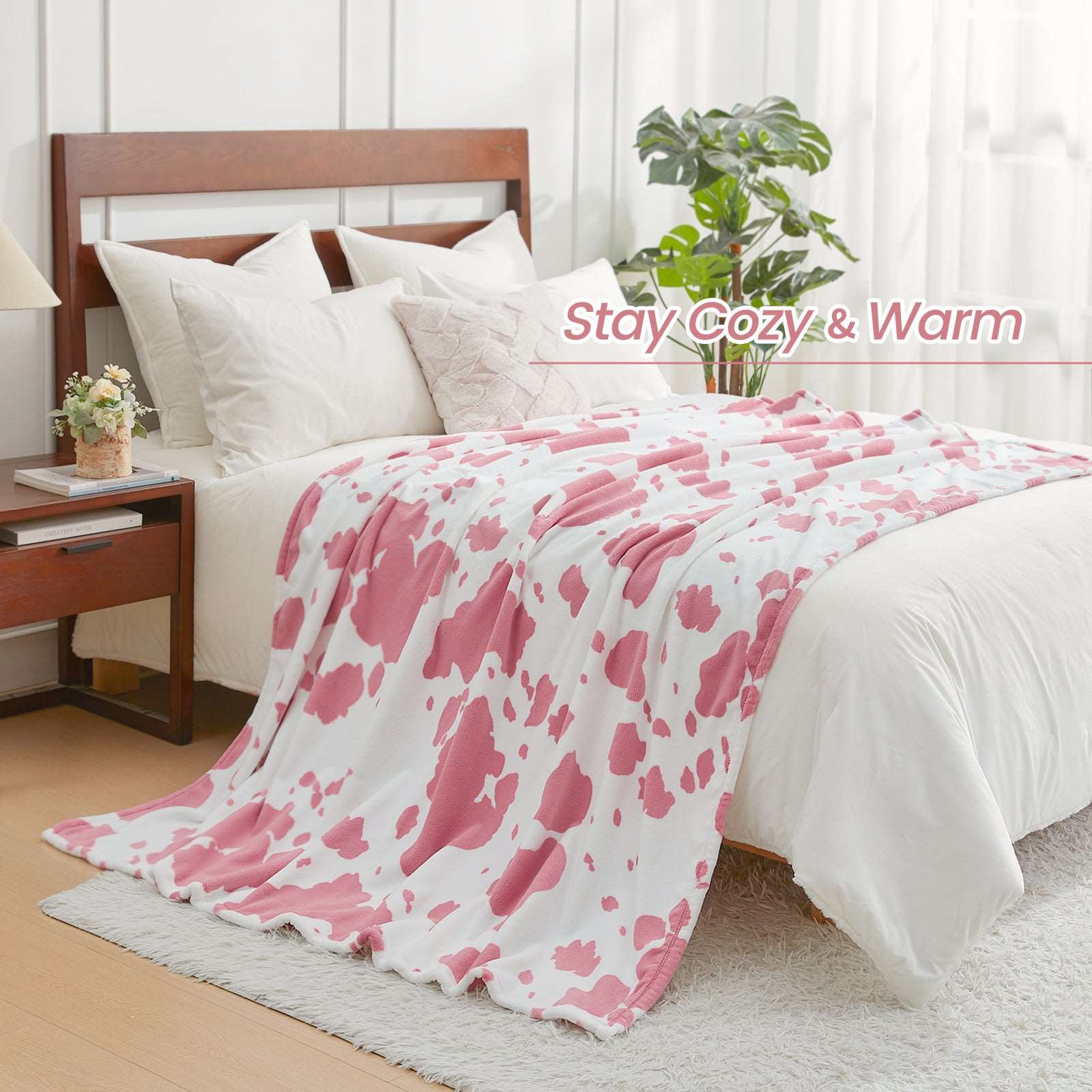 Pink cow print blanket on bed. Stay Cozy & Warm - Cozy Bliss #color_Strawberry