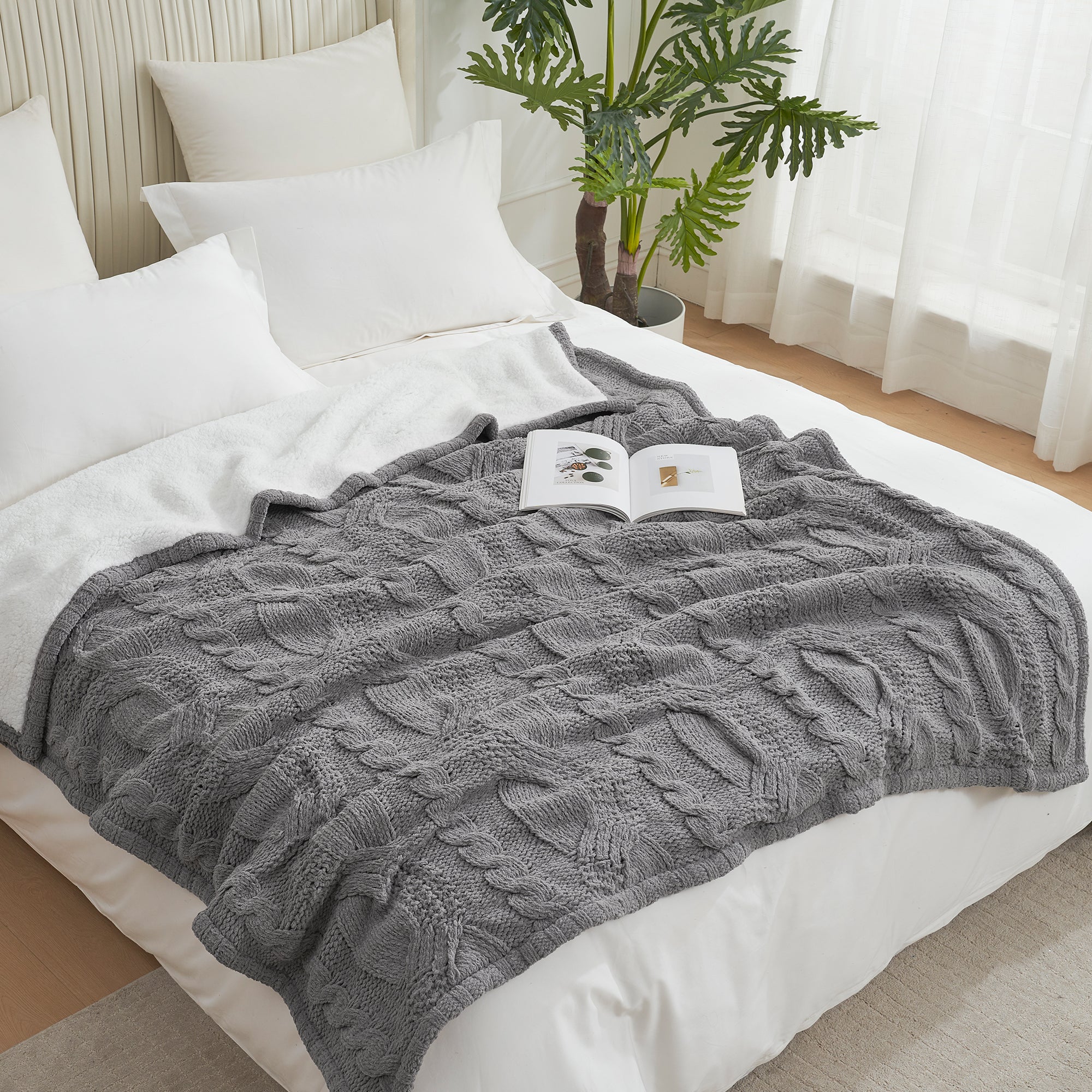 Gray knitted blanket on a bed with an open book, in a cozy bedroom setting. #Color_Grey