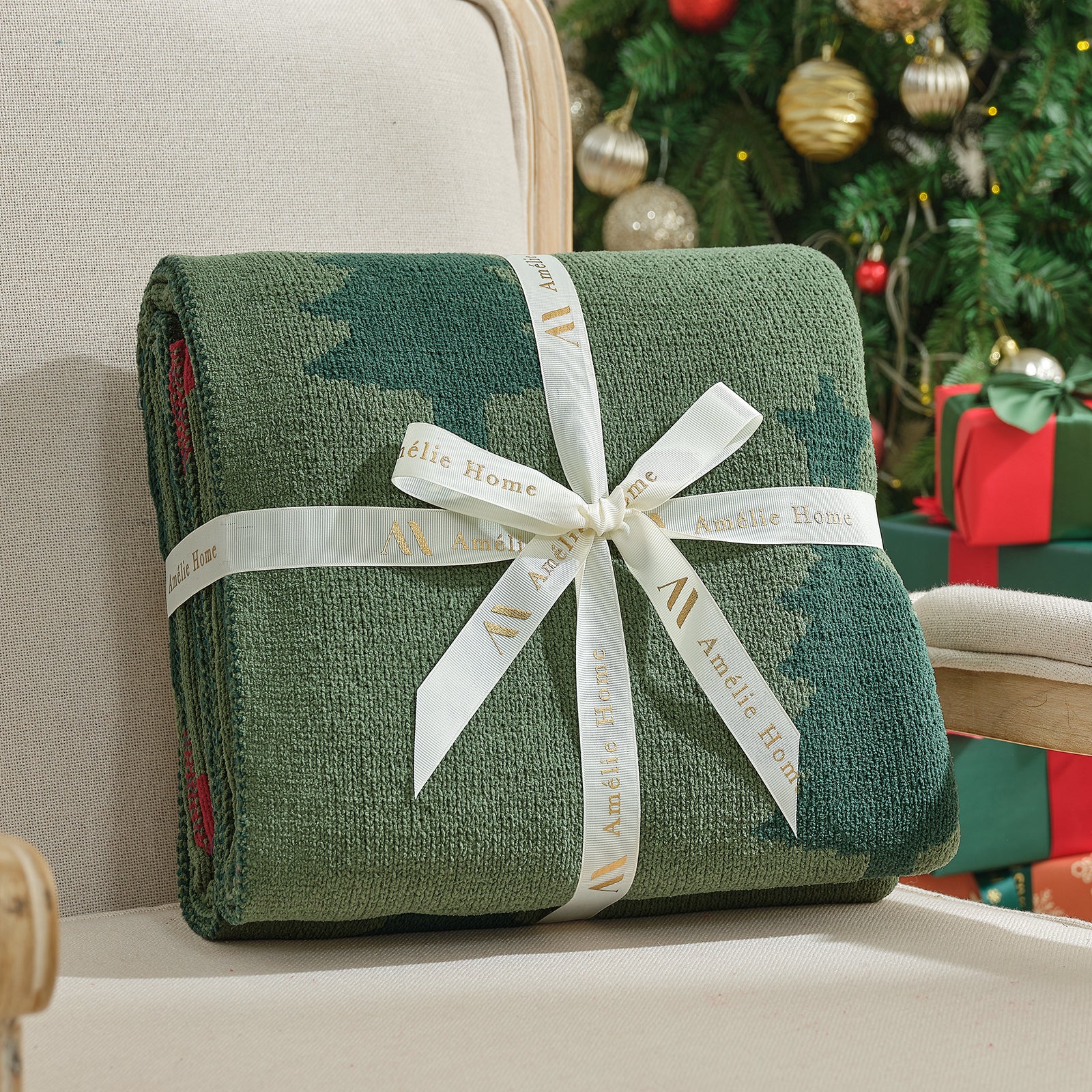 Green blanket with a white ribbon on a couch in front of a decorated Christmas tree. #color_Christmas Tree