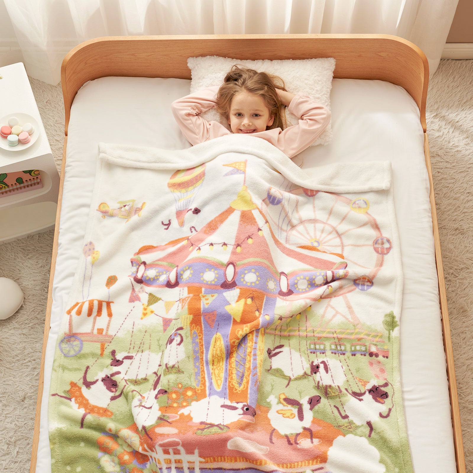 Child lying in bed under a colorful quilt with a carousel design. #color_Lamb Playground