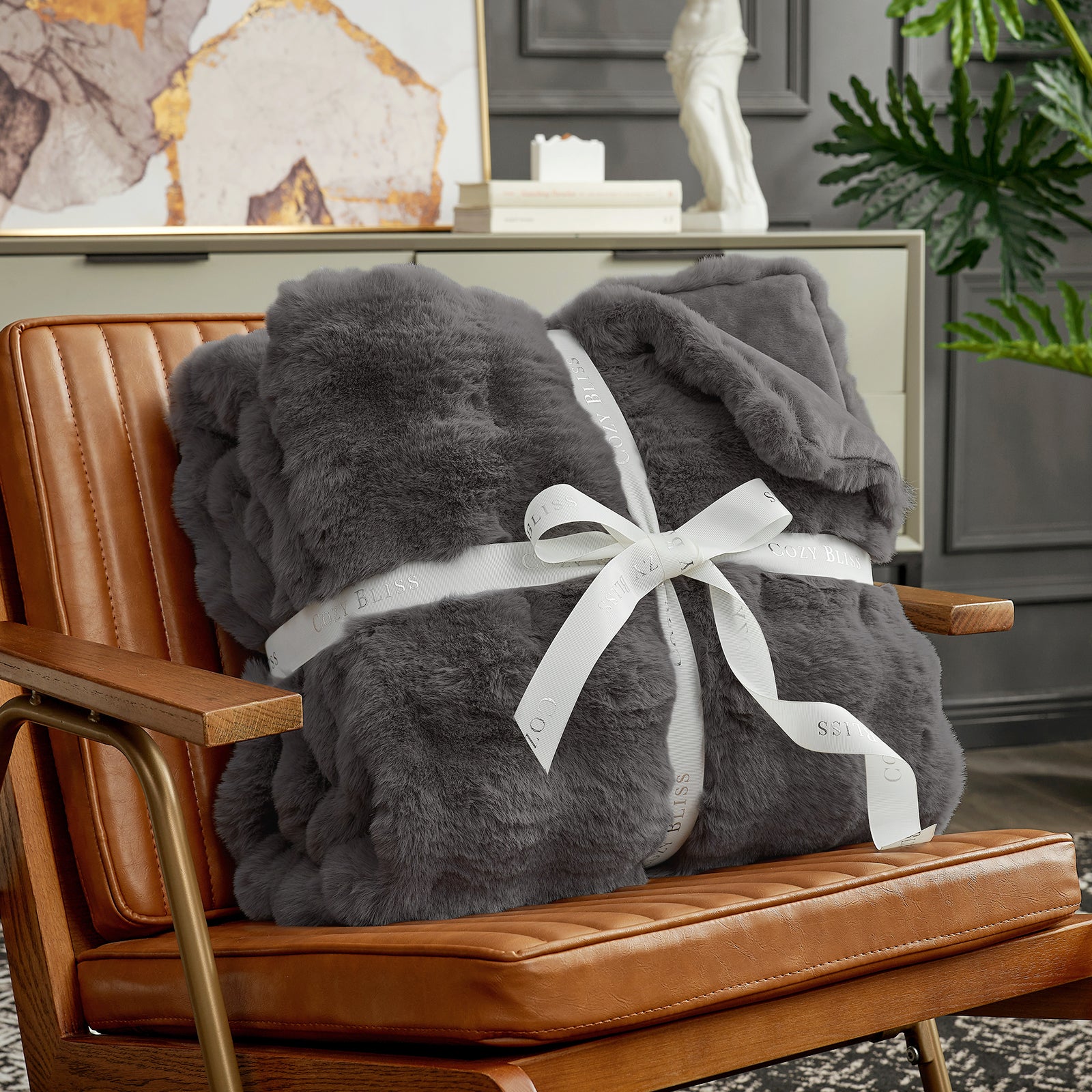 Fluffy charcoal grey blanket with a bow on a armchair. #Color_ Charcoal Grey